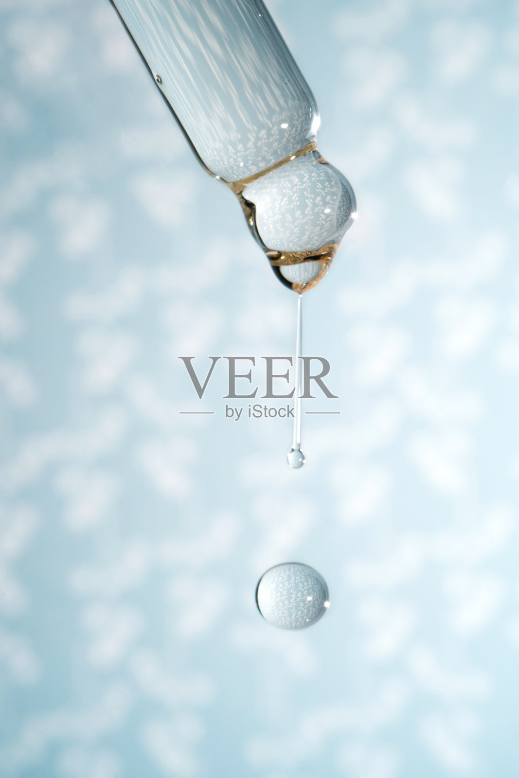 滴有化妆品凝胶的滴管。照片摄影图片