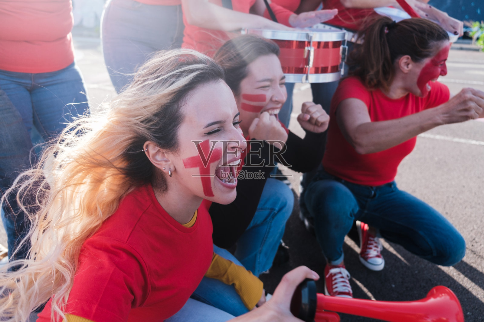 年轻的妇女们一起欢呼呐喊，支持当地的球队照片摄影图片