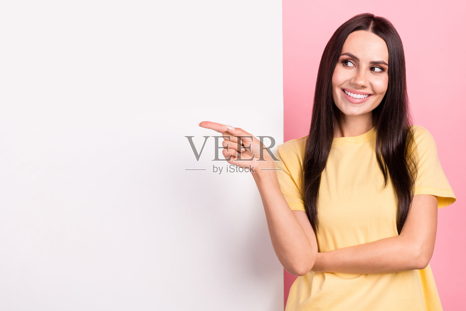 照片中漂亮梦幻的女人穿着黄色t恤，看起来像海报空白的空间孤立的粉红色背景照片摄影图片