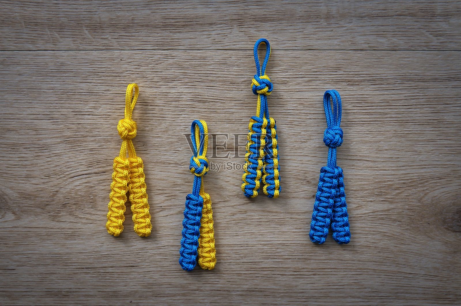 选择黄色和蓝色的装饰手工绳饰品排列在一个木制的桌子表面照片摄影图片