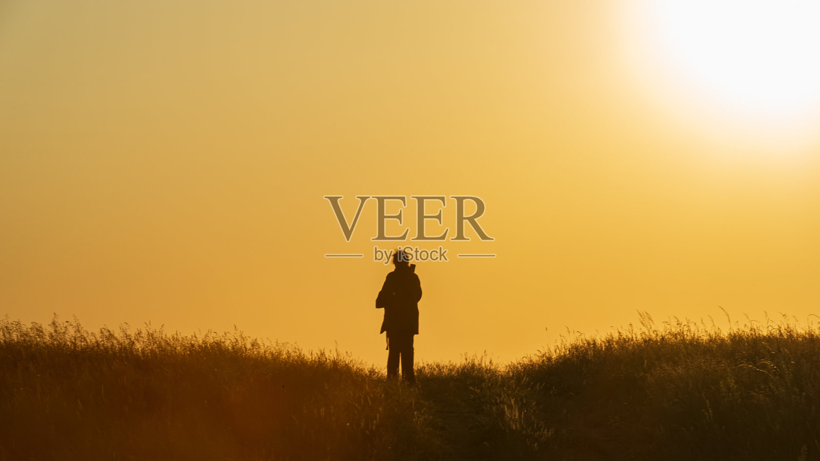 夕阳下奔跑的女人的剪影。照片摄影图片