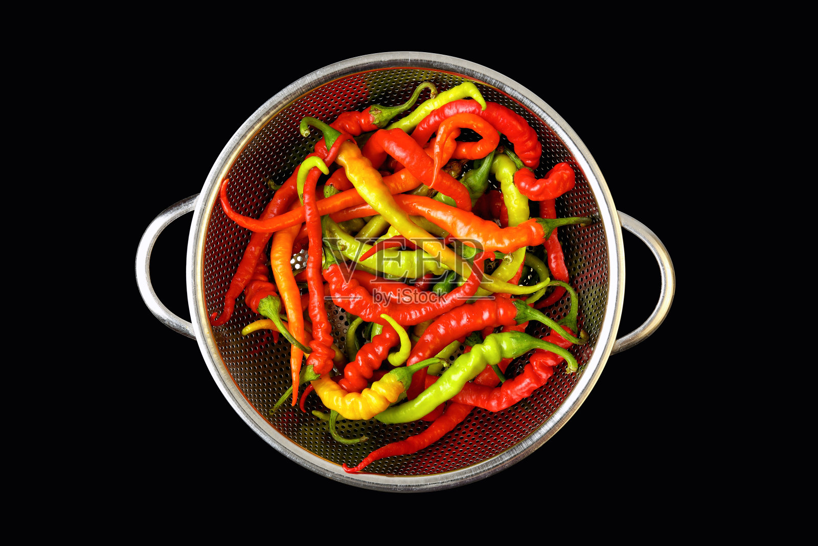 从上往下看，不同颜色的新鲜有机辣椒，放在黑色背景上的钢滤锅里照片摄影图片