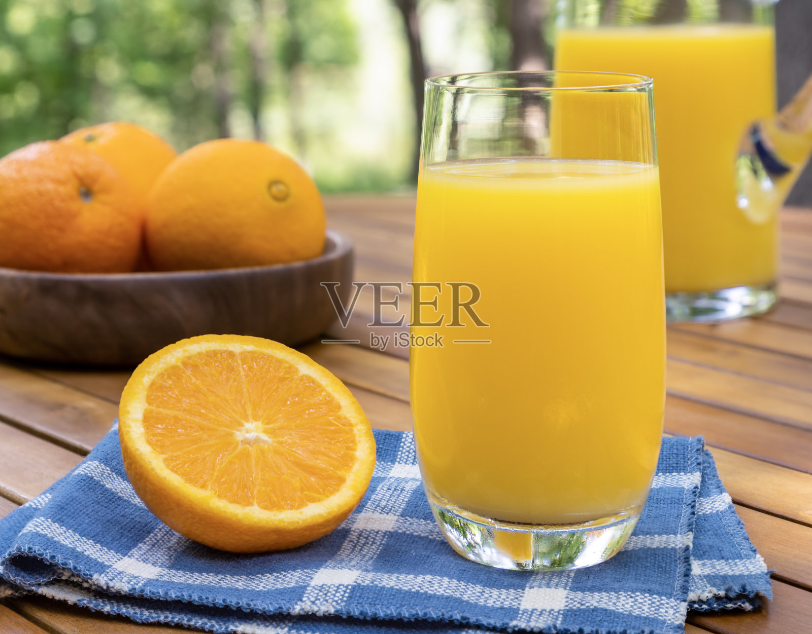 一杯橙汁放在户外的桌子上照片摄影图片