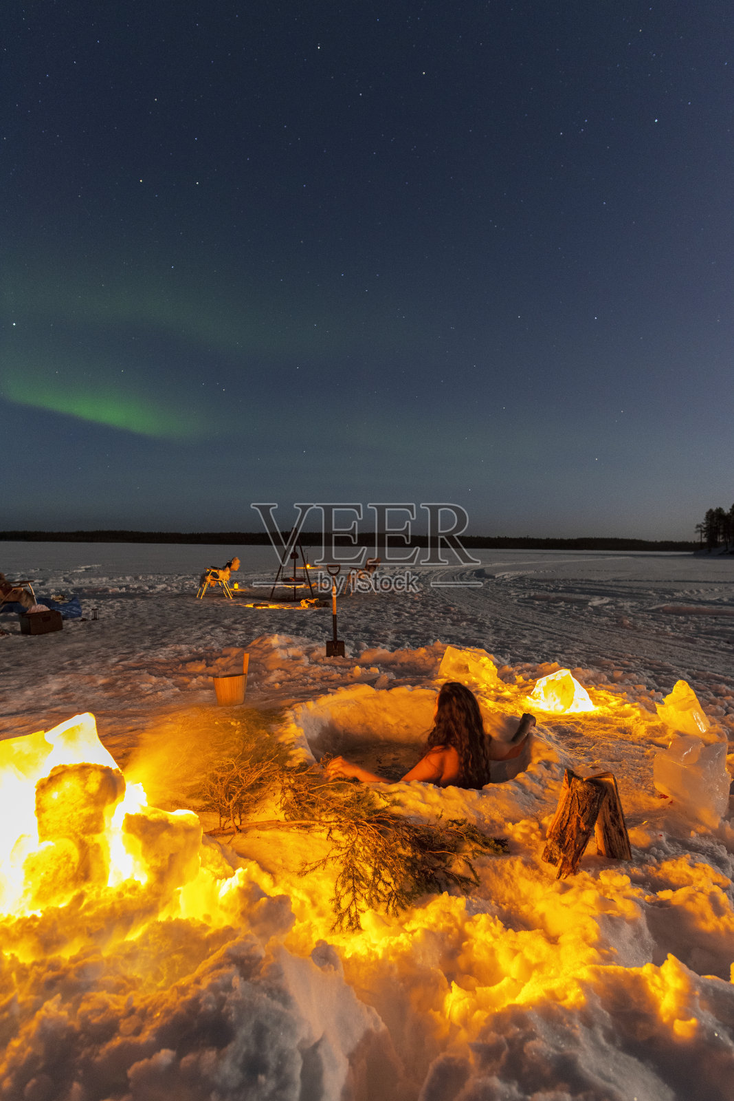 在冷水浴中享受北极光的女人照片摄影图片