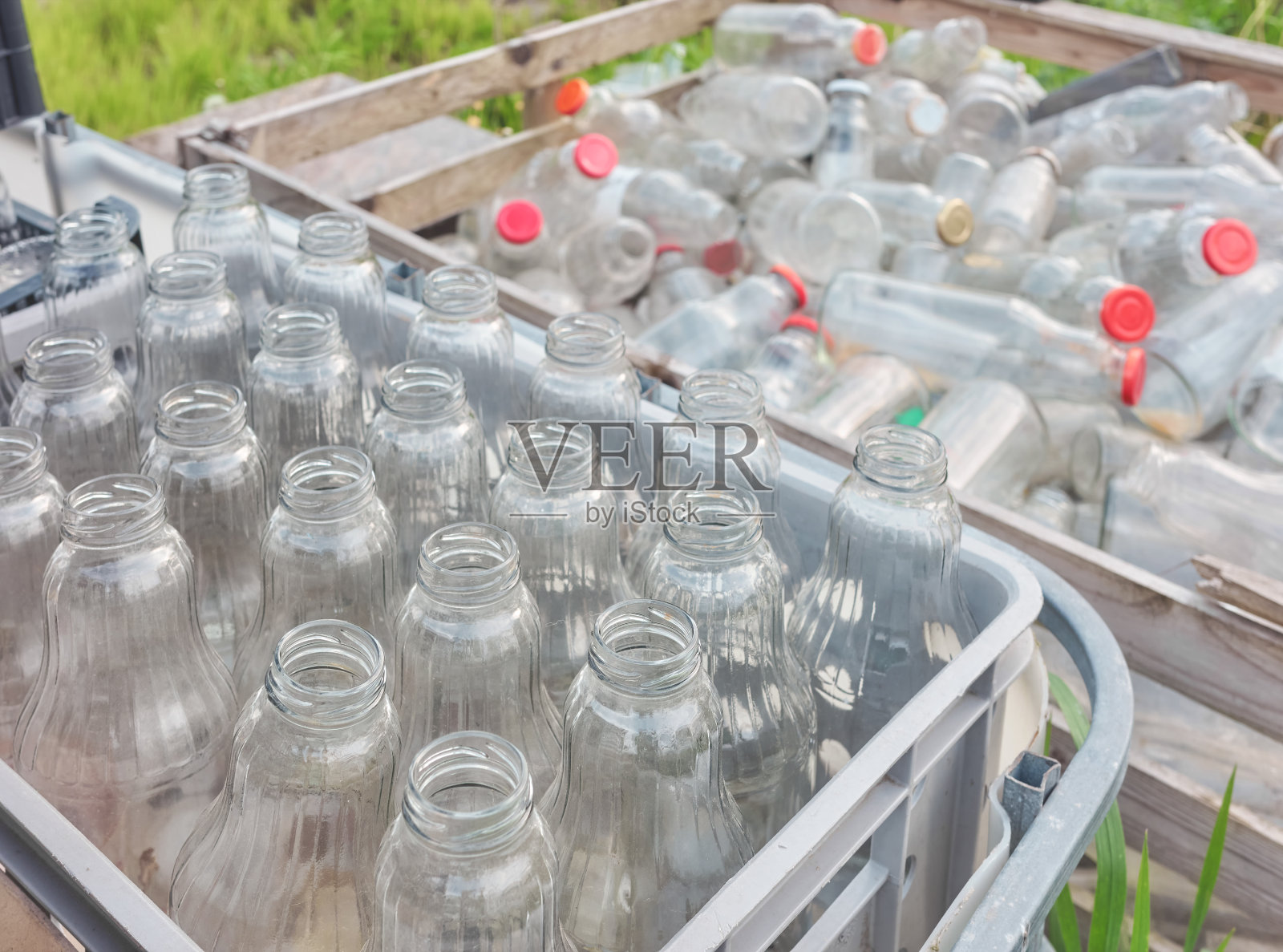 用空玻璃瓶存放于容器中，选择性聚焦。照片摄影图片