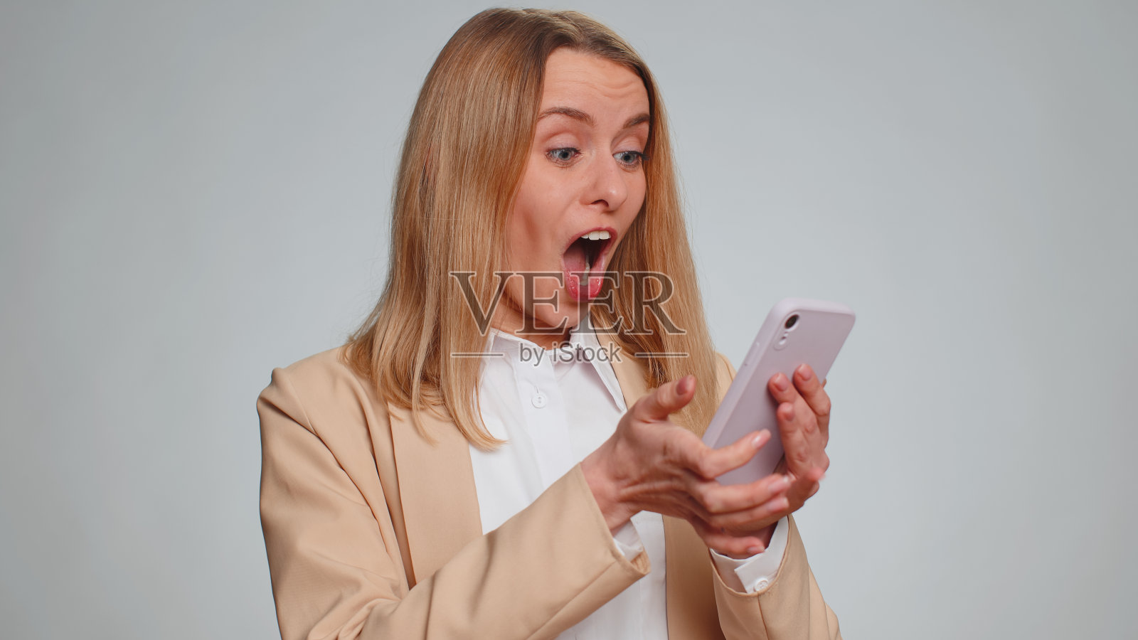 开心兴奋的女人用智能手机说，哇，是的，发现了伟大的大胜新闻，做了赢家的手势照片摄影图片