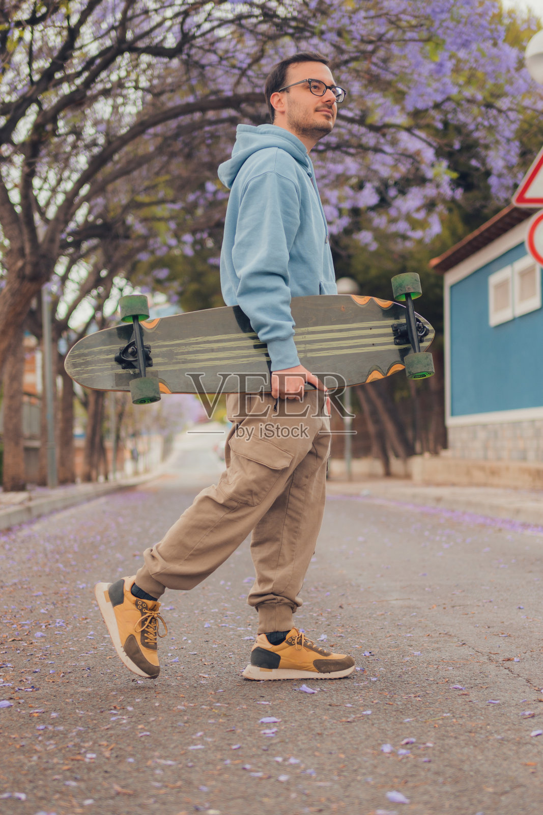 一个人拿着溜冰鞋走在大街上照片摄影图片