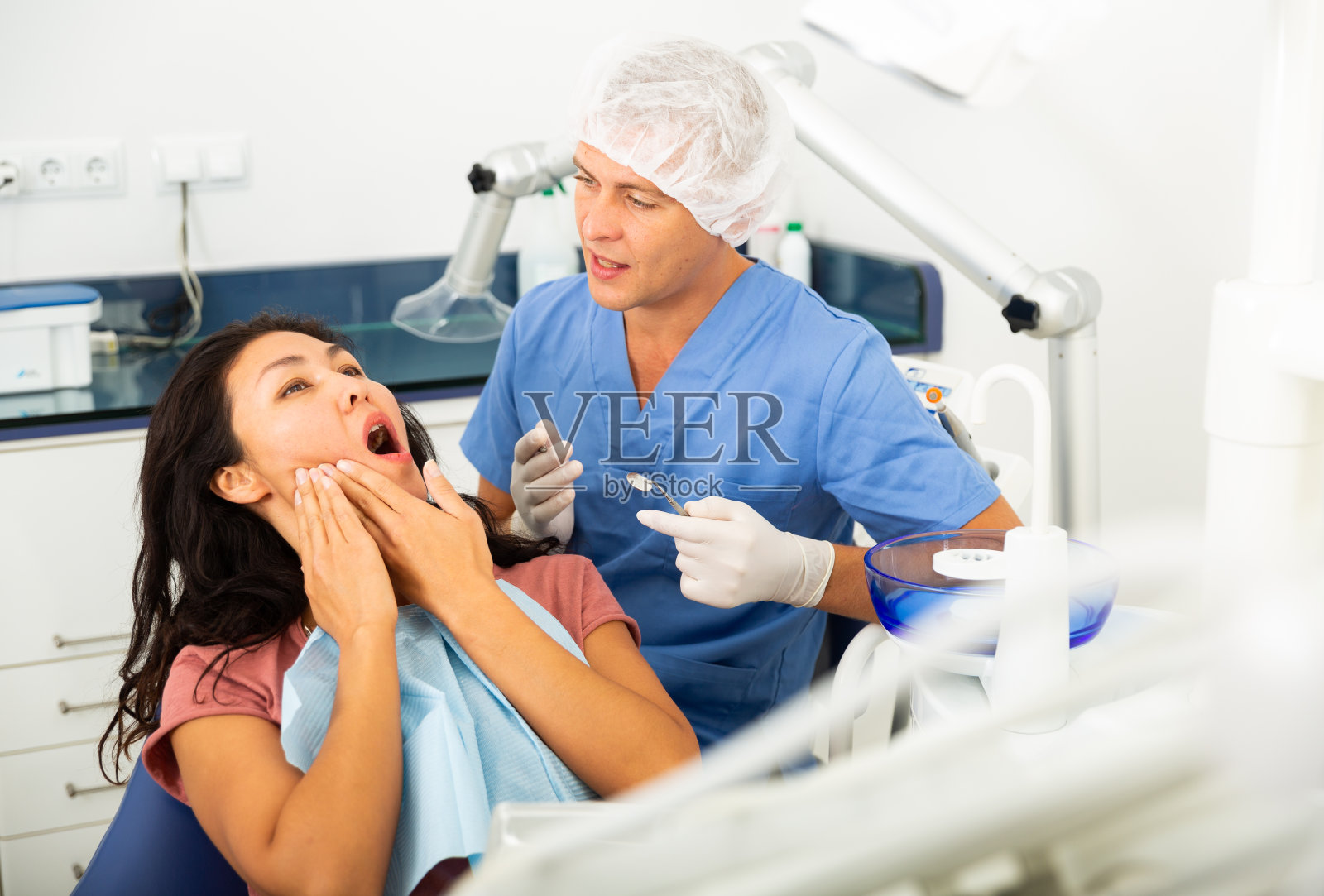 女人向牙医抱怨牙痛照片摄影图片