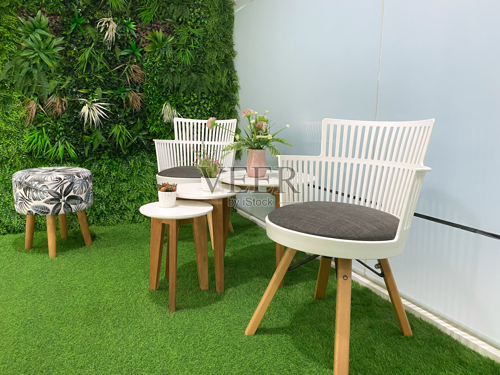 咖啡厅的角落，各种人造植物和木制桌椅的绿色和自然的细微差别照片摄影图片