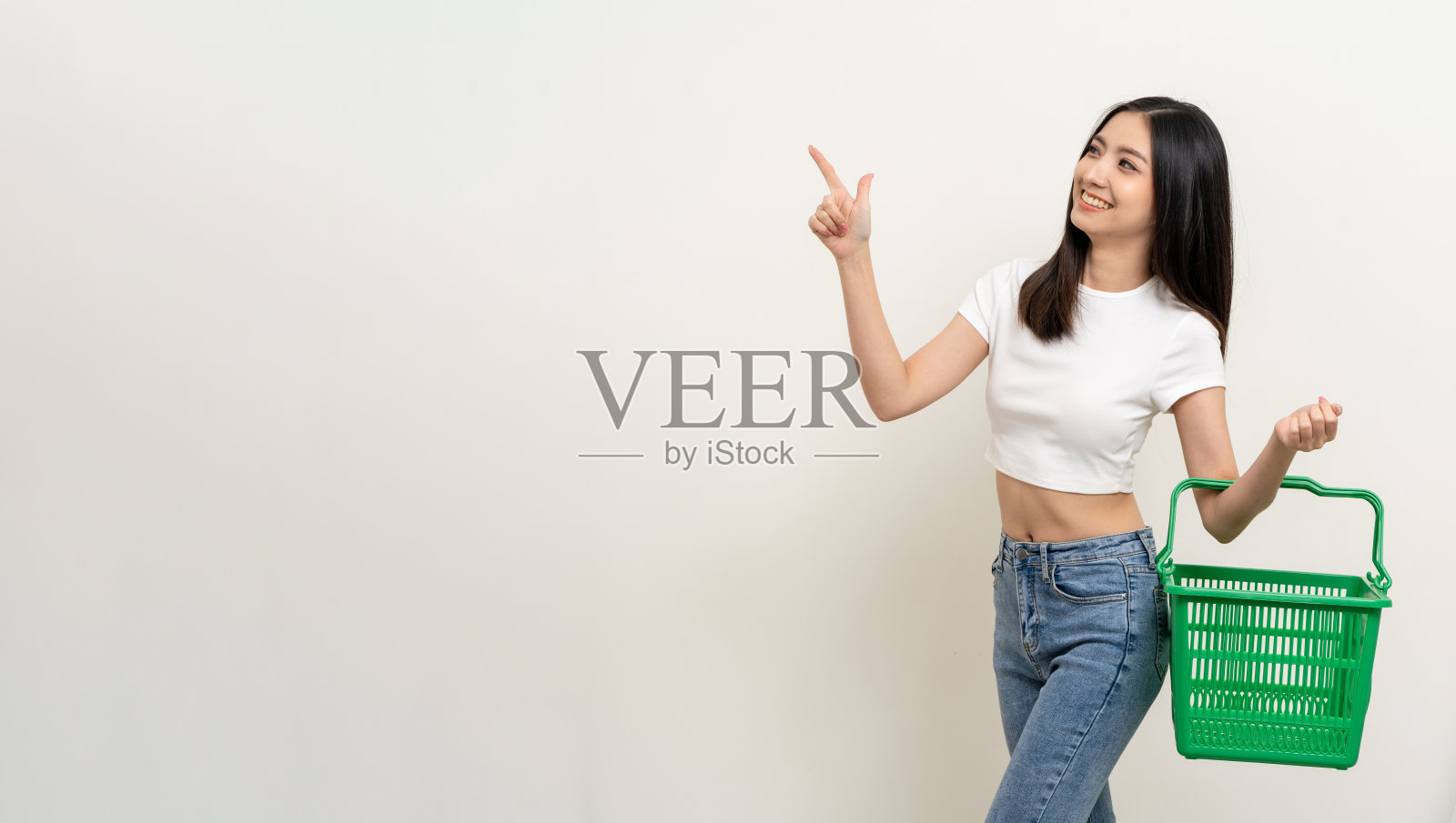 快乐的美女拿着购物篮。肖像美丽的亚洲女性在时尚风格站姿孤立的背景。年轻的亚洲女性在网上市场购物照片摄影图片