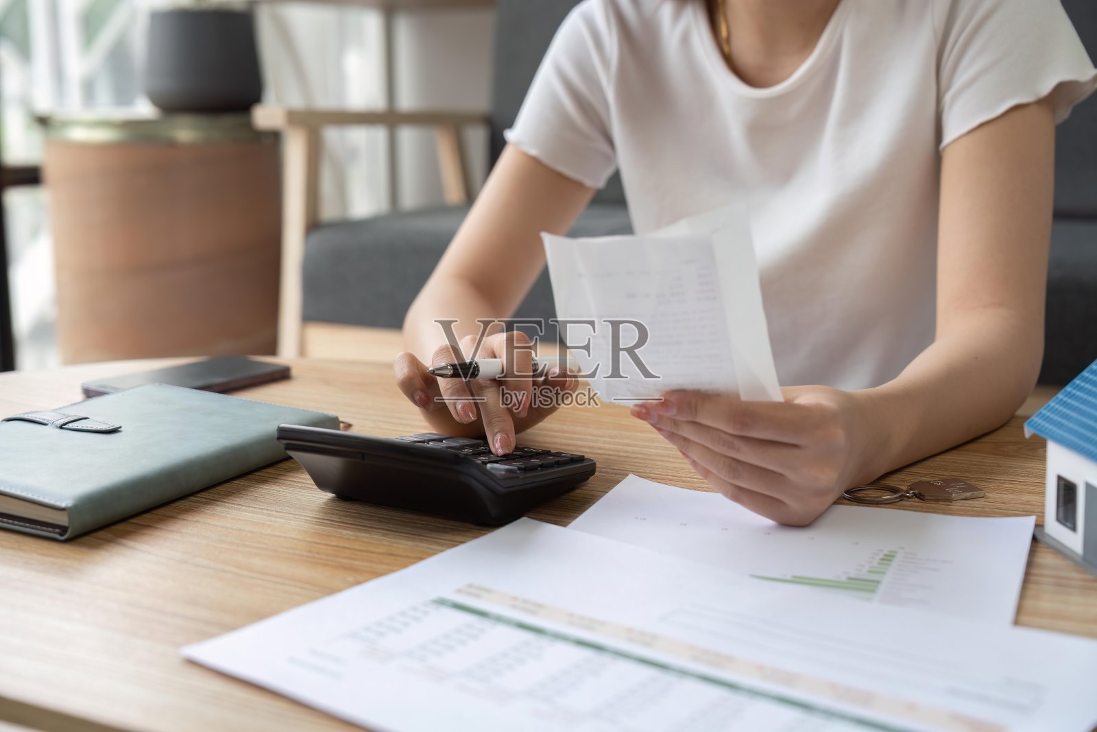 年轻女子在家里的客厅里检查账单、税收、银行账户余额和计算开支照片摄影图片