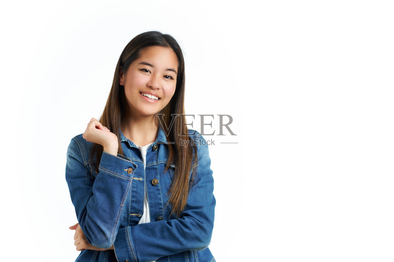 年轻的亚洲女子，平静而感恩的姿态，孤立在白色的背景下，穿着牛仔夹克照片摄影图片