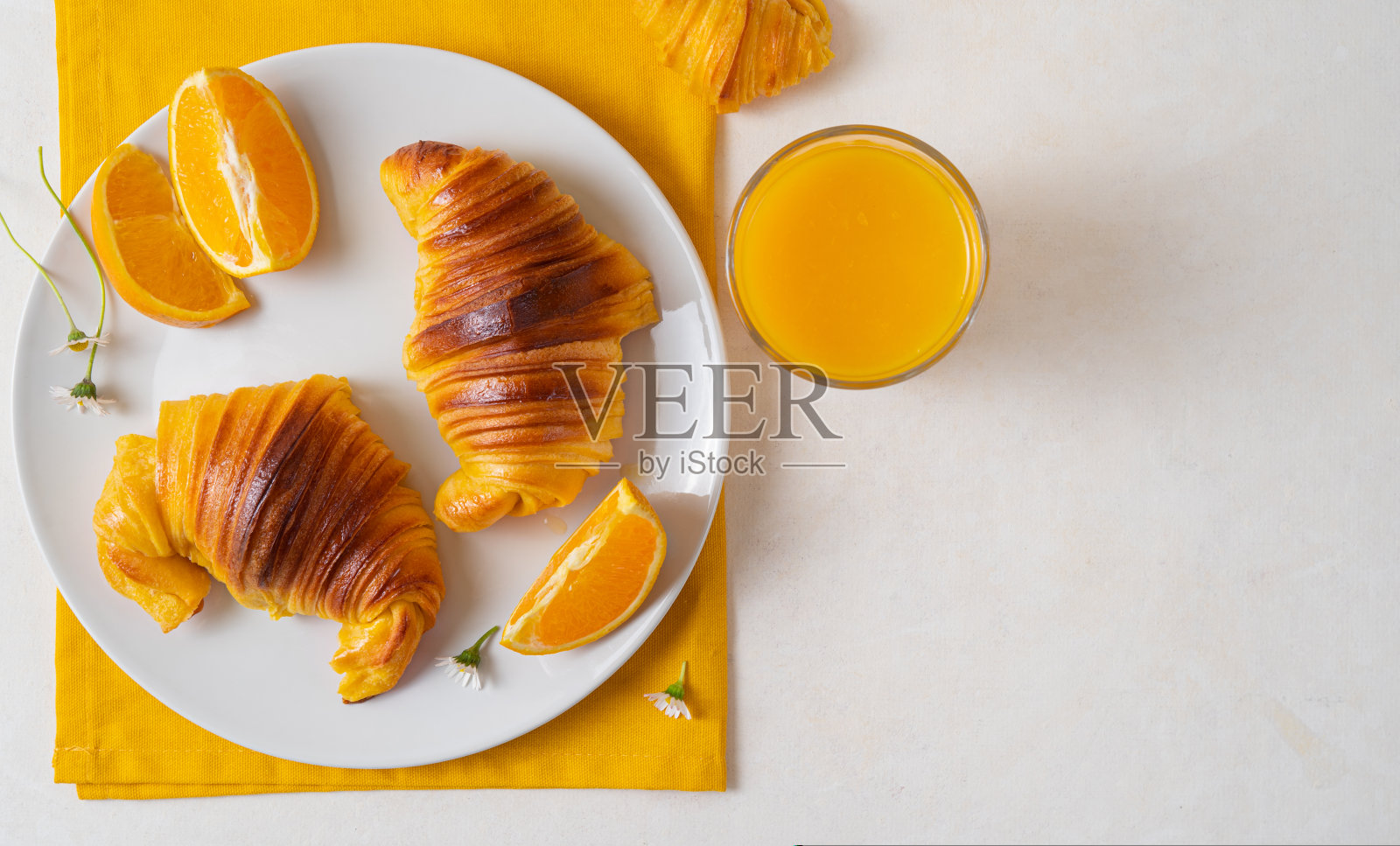 奶油蛋糕牛角面包放在盘子里，配上橙汁照片摄影图片