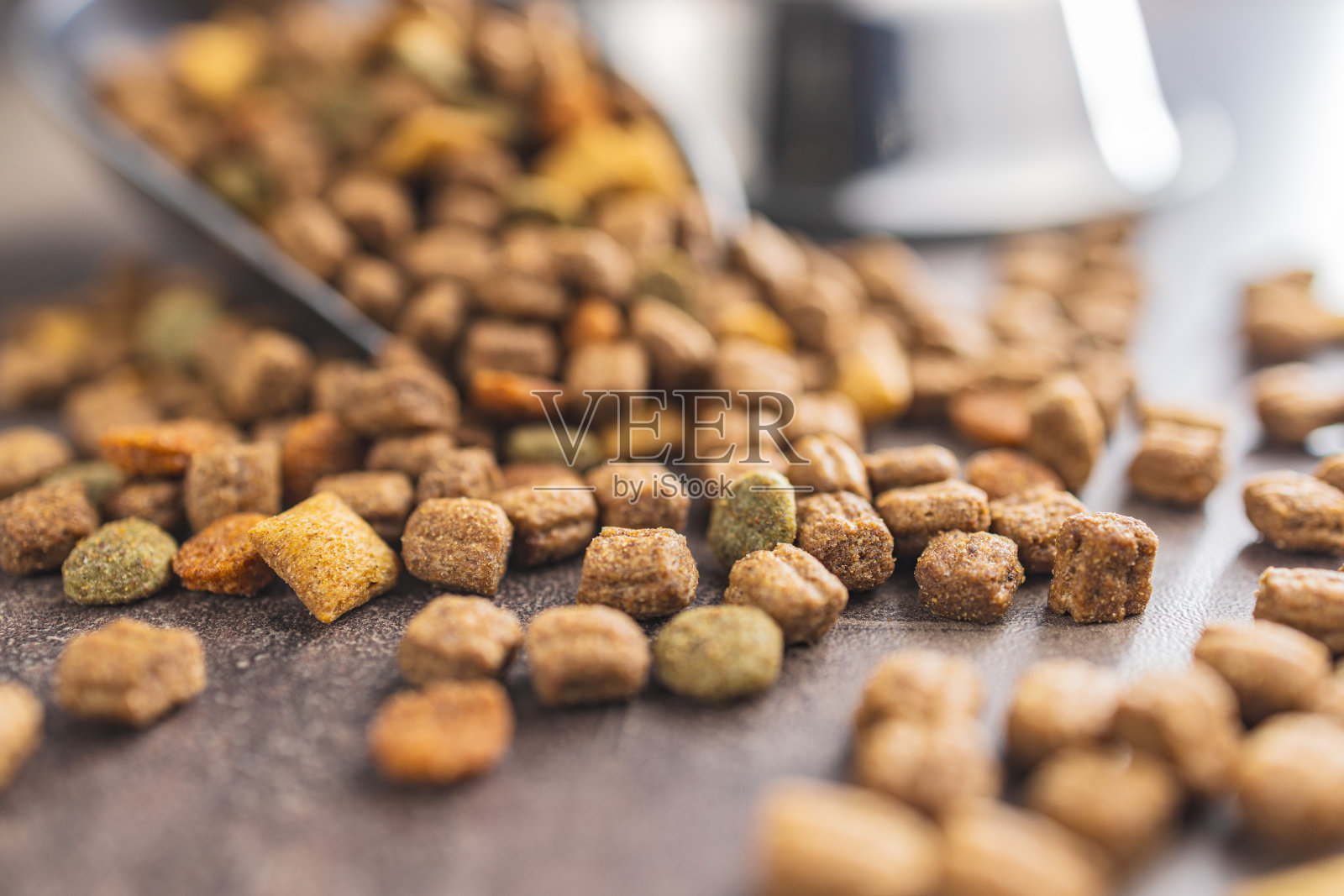 干碎宠物食品。旧桌子上的狗粮或猫粮。照片摄影图片