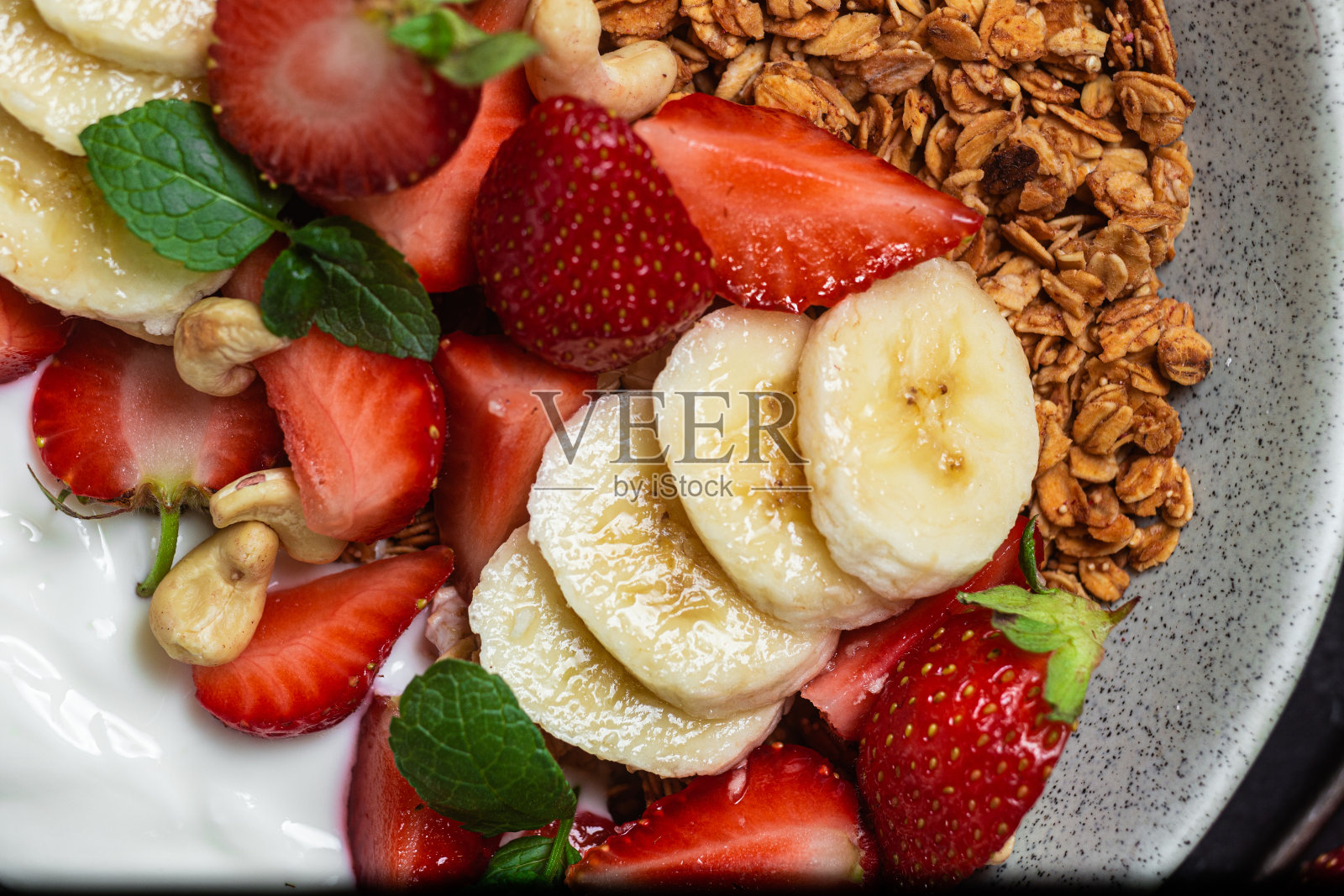 格兰诺拉麦片配酸奶，草莓和香蕉在碗里照片摄影图片