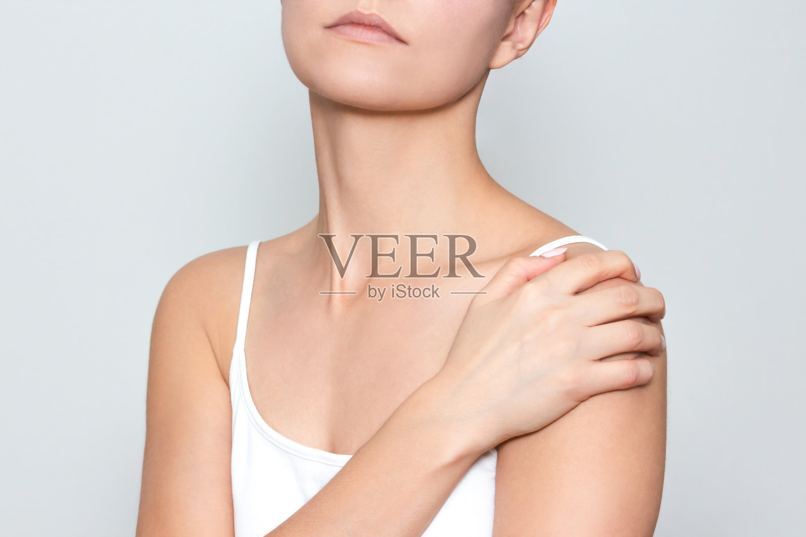 一个女人用手托着她的肩膀，患有严重的肩部疼痛照片摄影图片