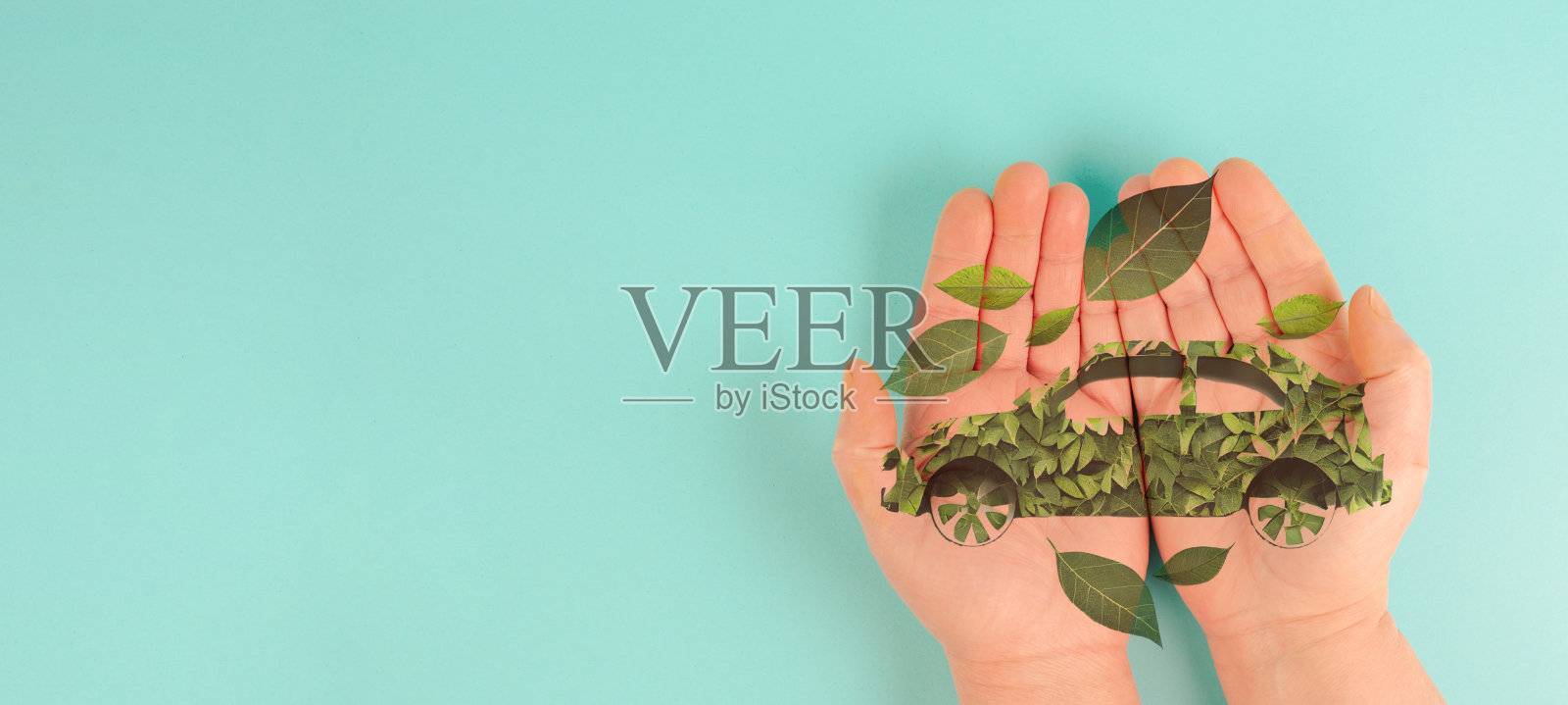 手持由树叶制成的绿色电动车，资源可持续再生，生态动力，环保问题照片摄影图片