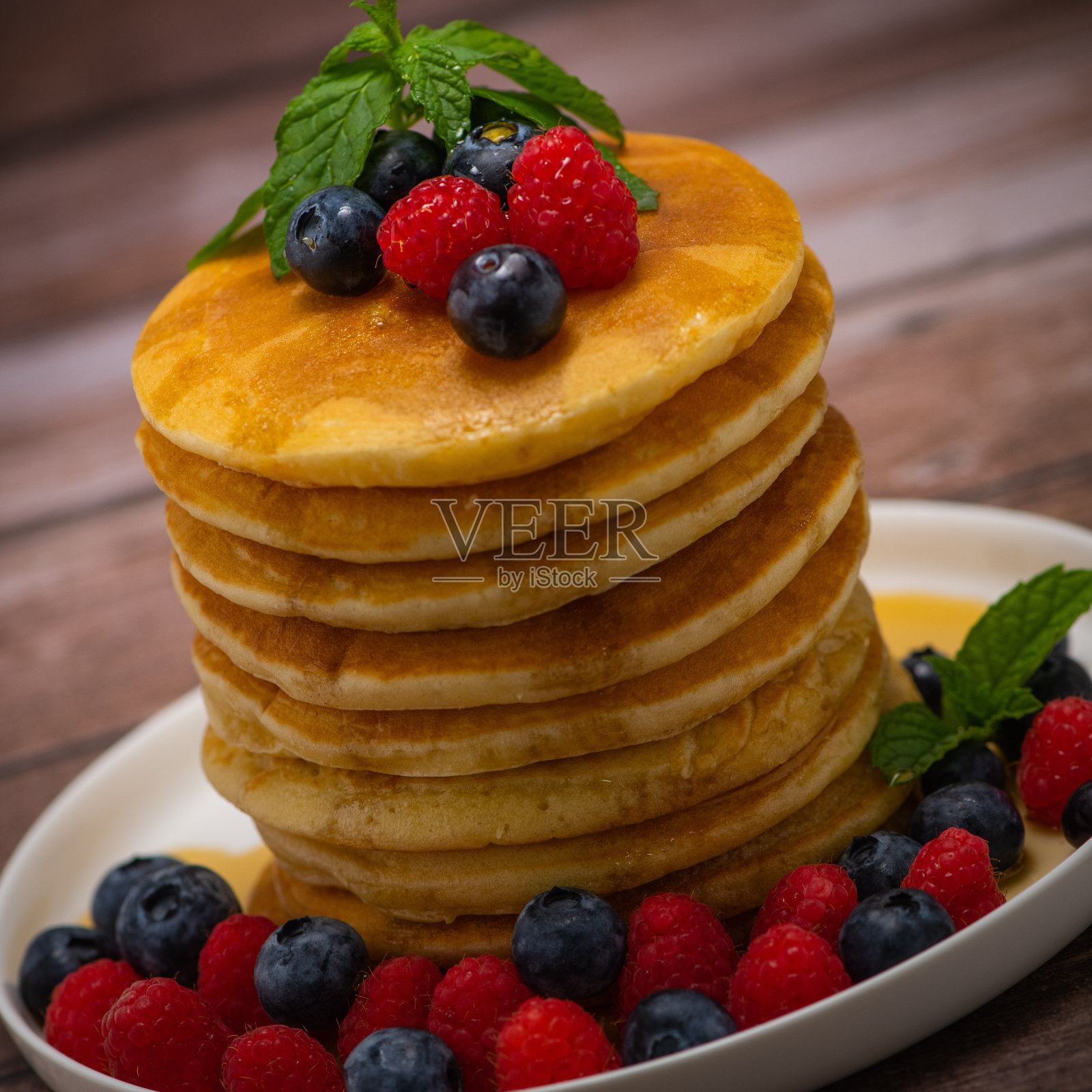 枫糖浆煎饼配覆盆子和蓝莓馅照片摄影图片
