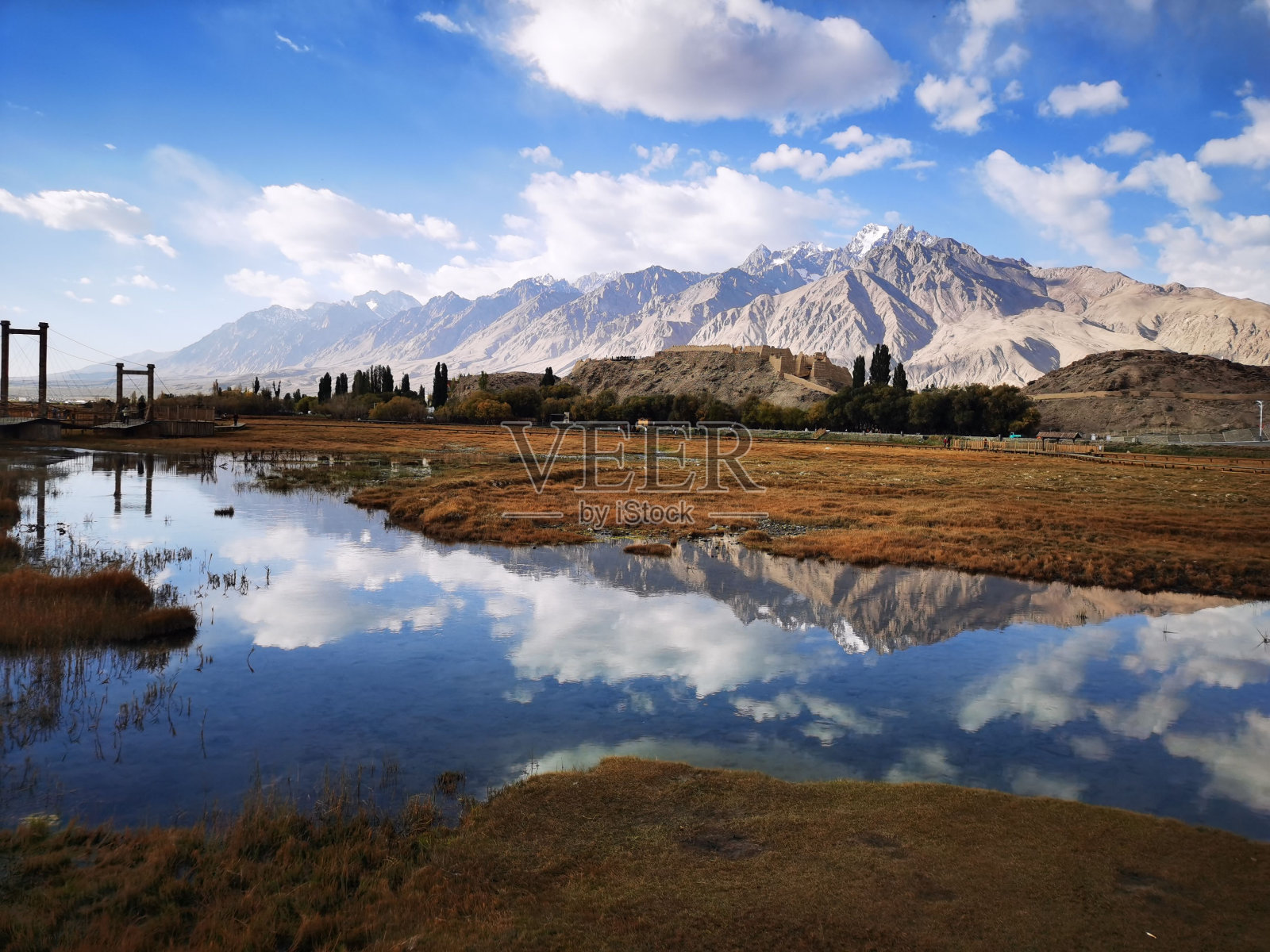 连绵起伏的丘陵，周围是白雪皑皑的山峰和波光粼粼的蓝色湖泊照片摄影图片