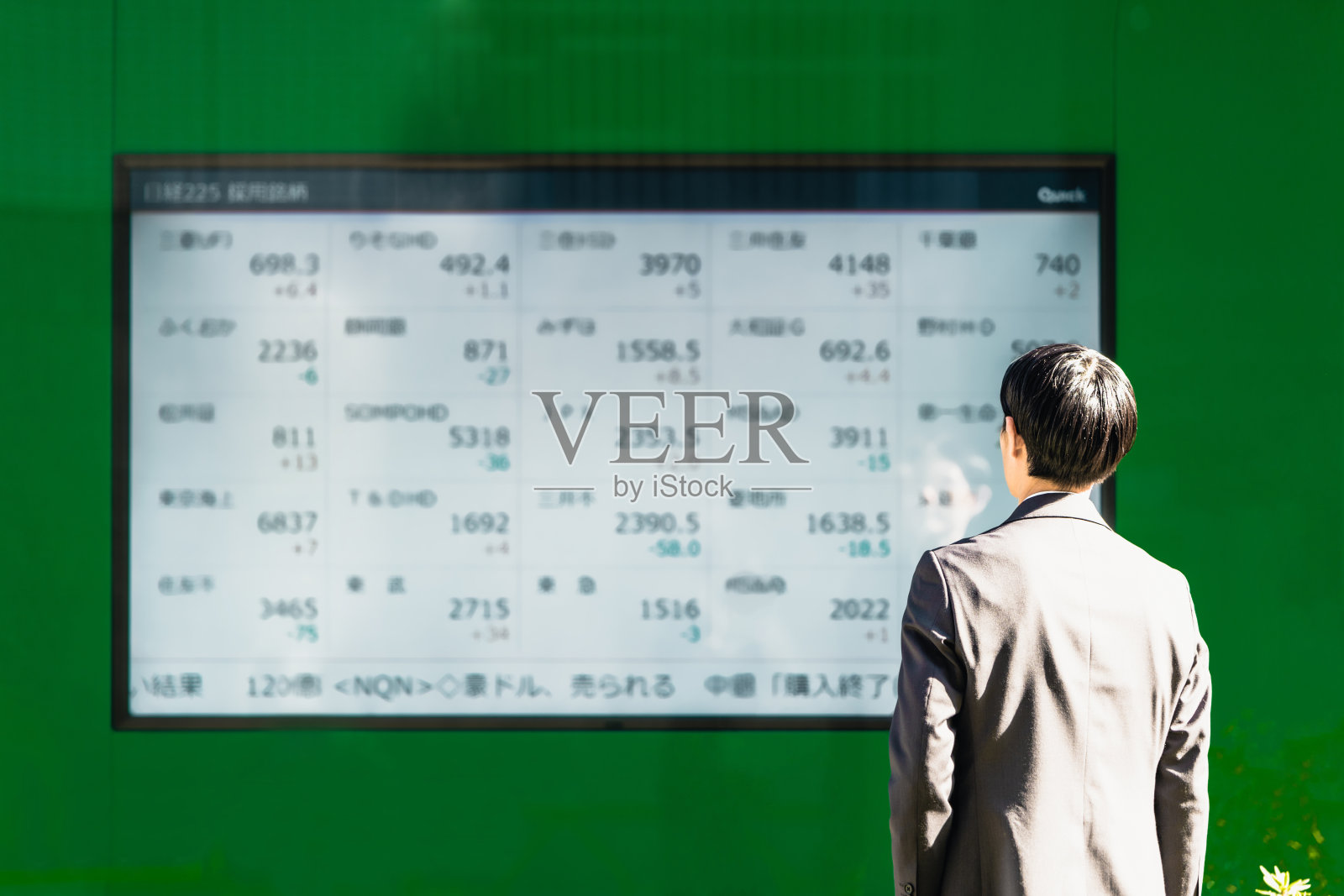 在电子公告板上看股票的30多岁的商人投资者照片摄影图片