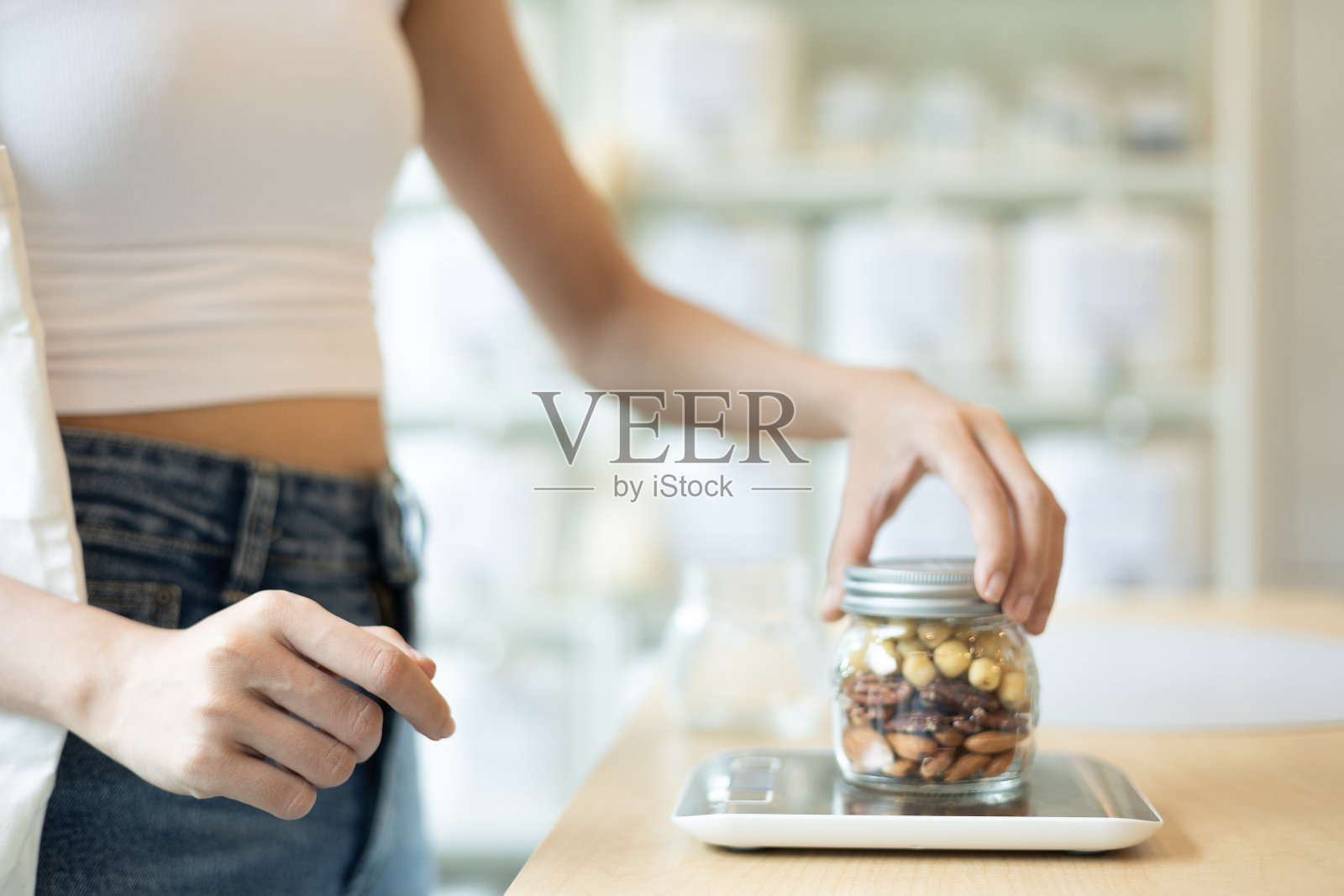 一位年轻的亚洲妇女正在用可重复使用的袋子在商店里挑选和购买有机产品。无塑料意识极简主义素食可持续无塑料生活方式概念。照片摄影图片