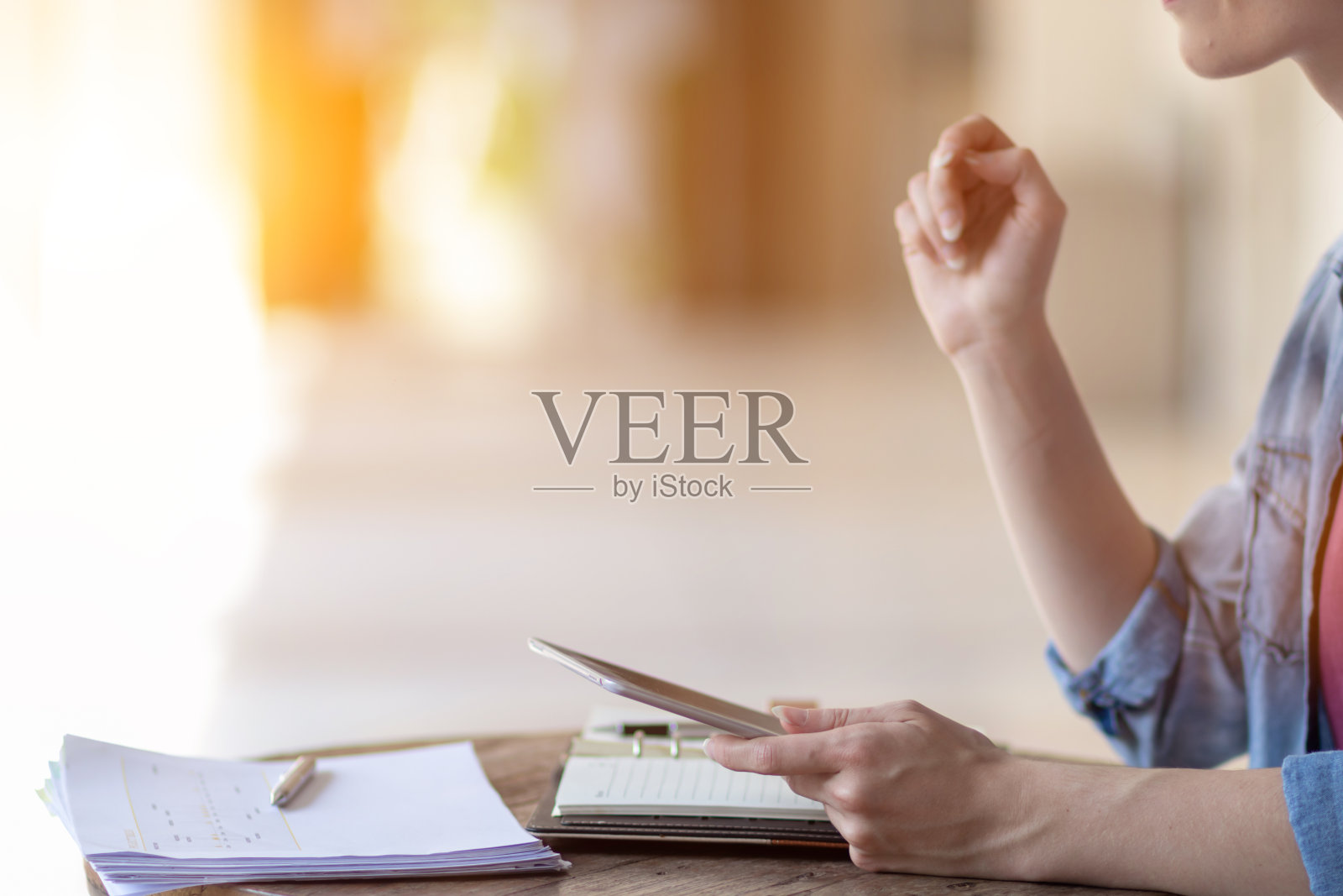 年轻女性在家工作，使用平板电脑搜索信息，与同事交流在线工作。通过在线系统使用平板电脑在家工作的概念。照片摄影图片