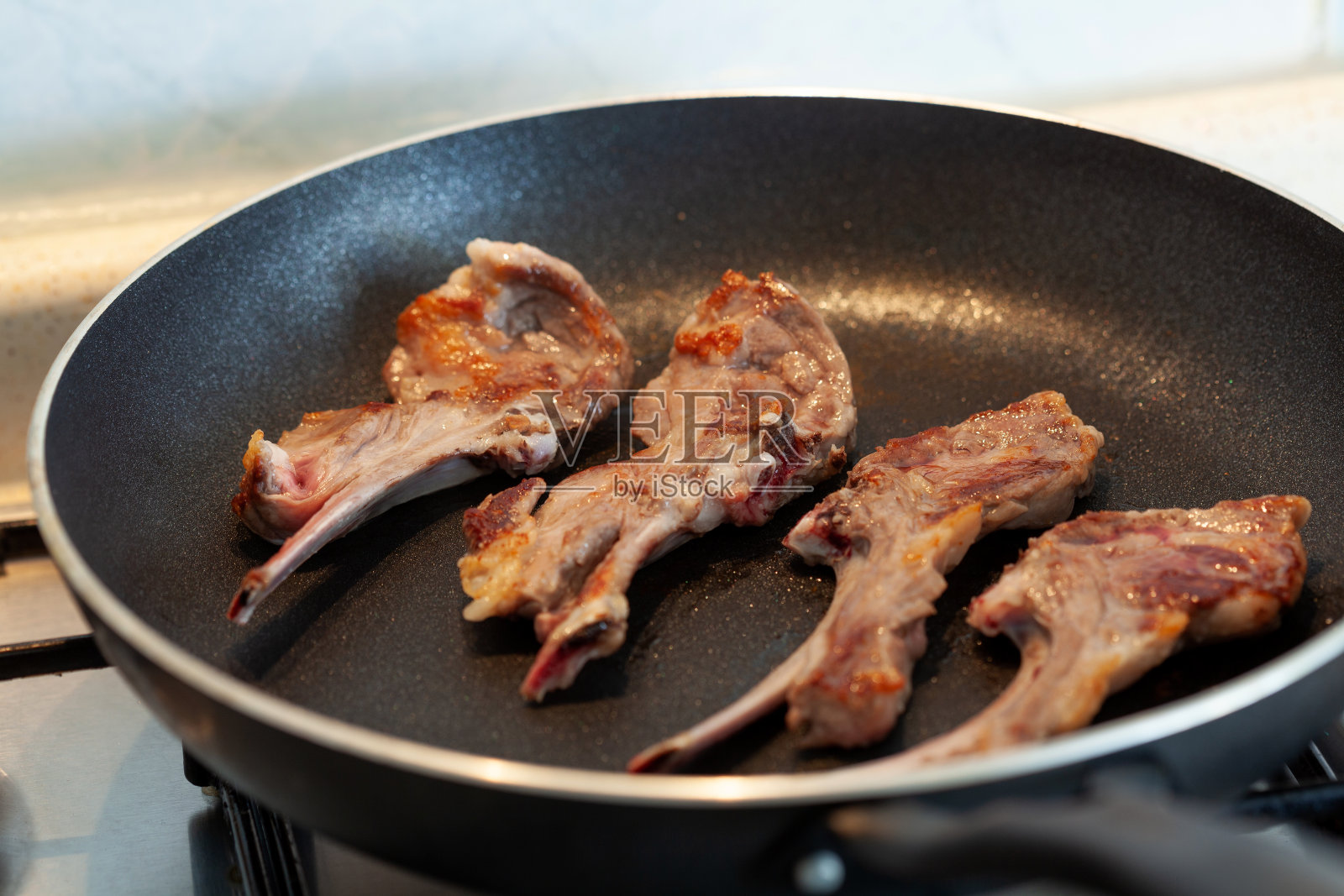 在黑锅上煮熟的肉排照片摄影图片