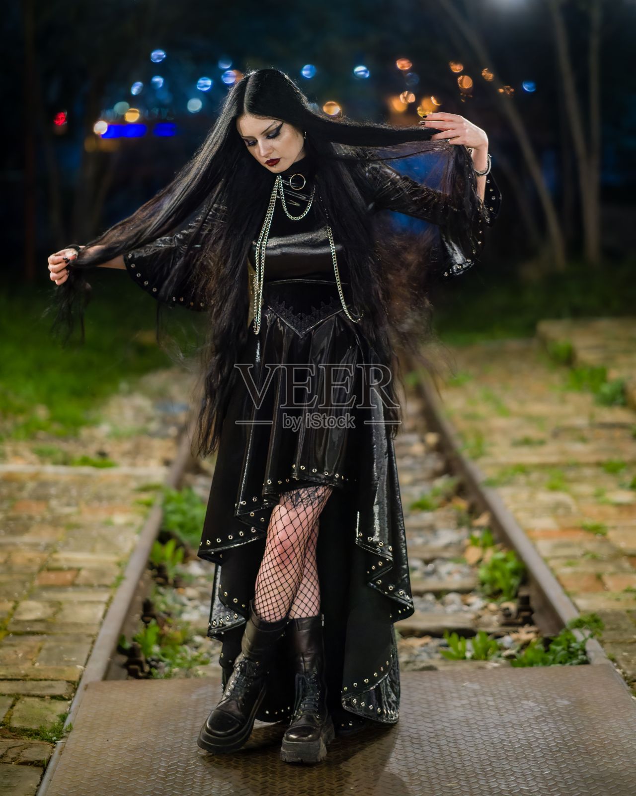 一个穿着哥特式服装的性感女人在夜间在户外摆姿势的肖像照片摄影图片