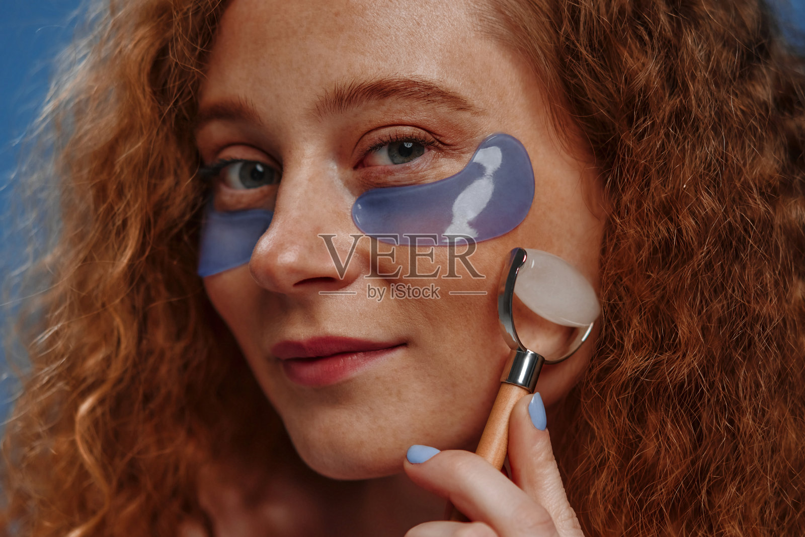 蓝色背景上有雀斑的红发女孩照片摄影图片