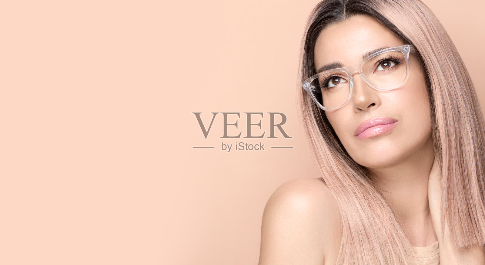 美丽的女人戴着时髦的裸色眼镜或眼镜，若有所思照片摄影图片