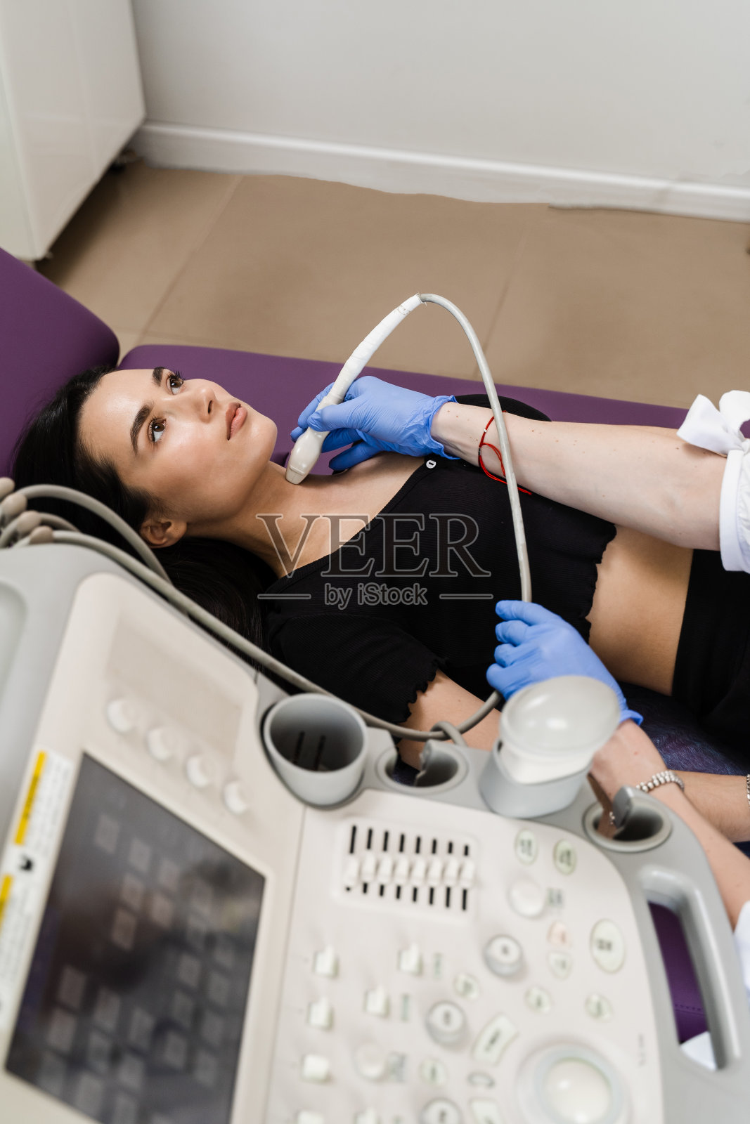 医生在诊所为女孩进行甲状腺超声检查，诊断甲状腺肿瘤、囊肿或甲状腺肿大。照片摄影图片