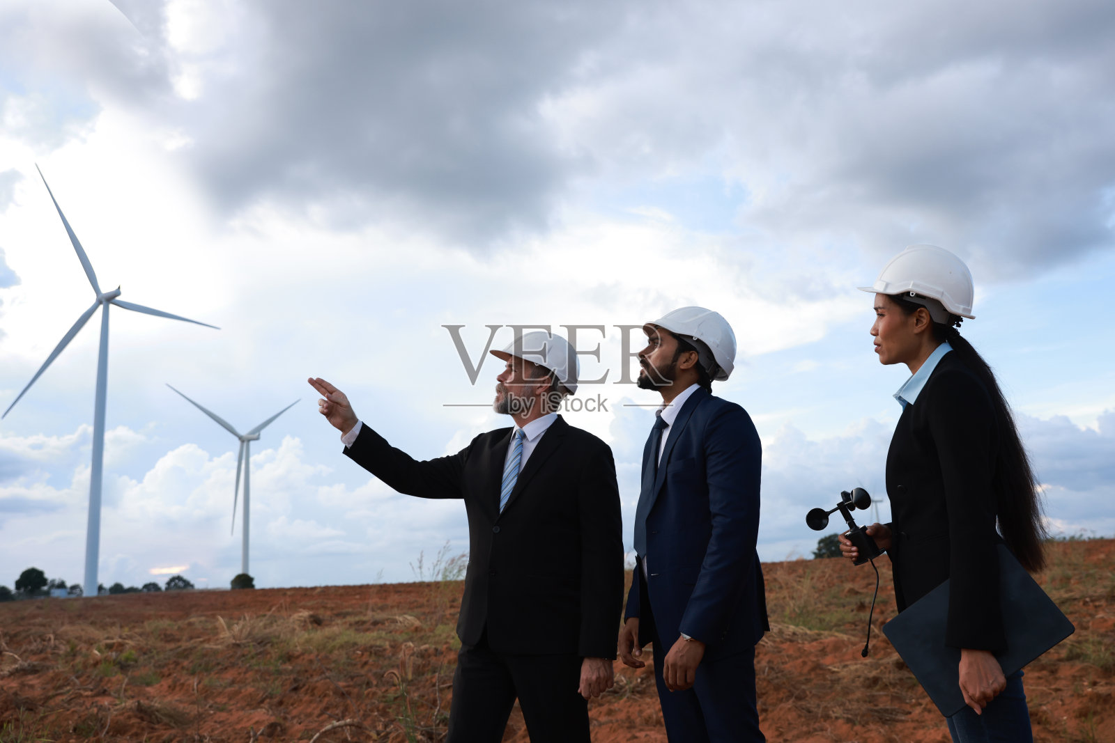 一群投资者参观使用风力涡轮机的可再生能源项目。风力发电场，风力涡轮机，风能的可再生能源。照片摄影图片