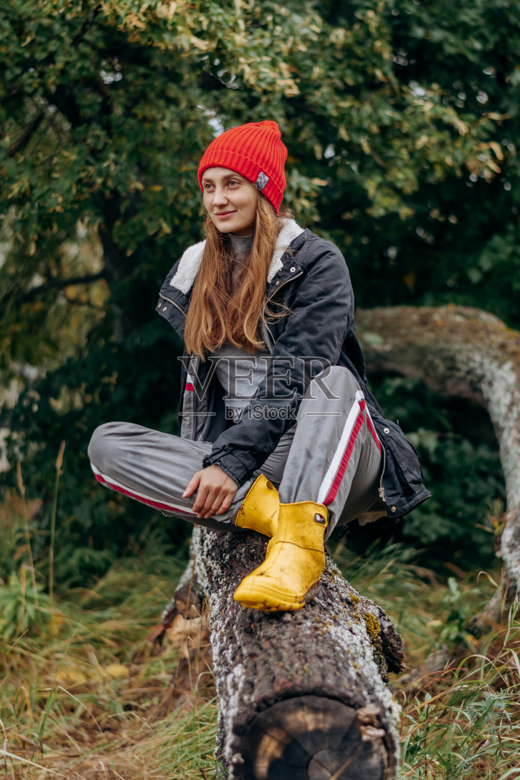 一个快乐的年轻女子走在树林里欣赏风景。秋天，旅行，户外探险，慢生活理念照片摄影图片