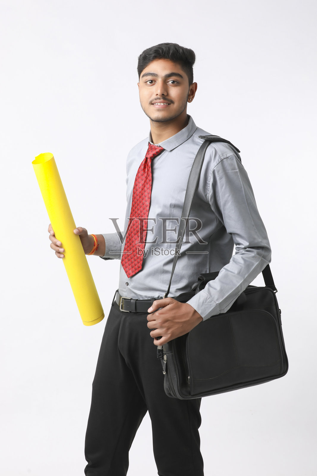 年轻的印度工程师戴着黄色安全帽，做出成功的手势。照片摄影图片