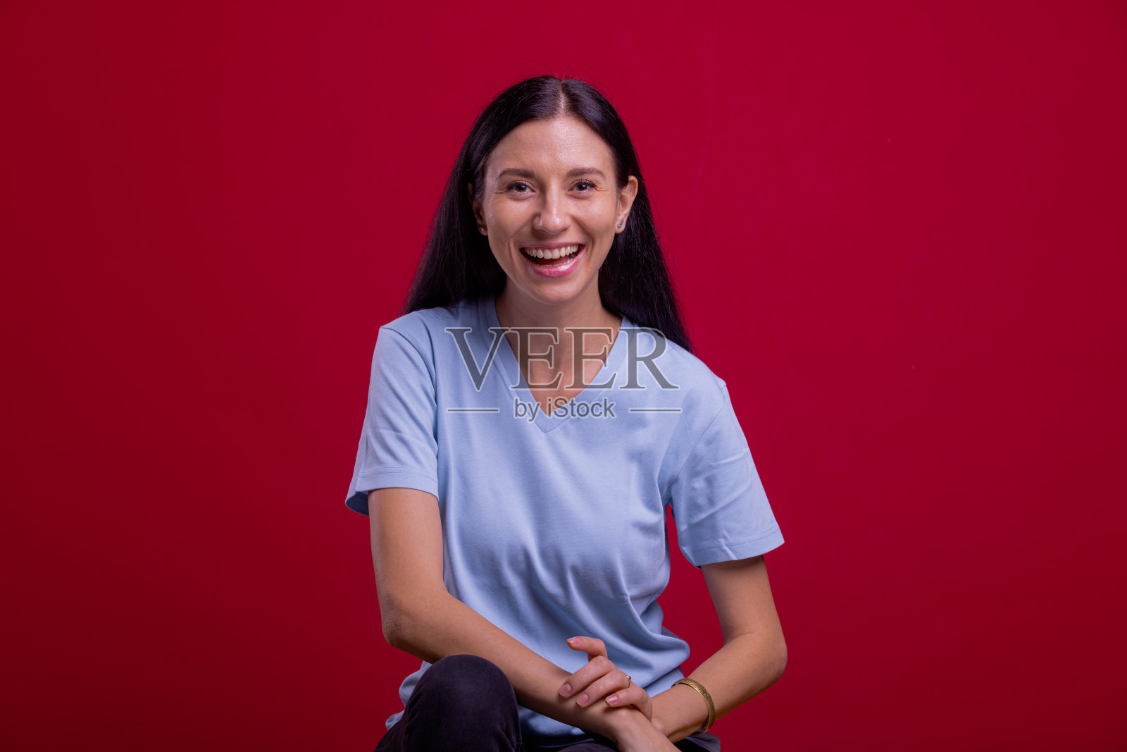 快乐自信的女人。美丽的东欧女人的肖像在红色的背景。照片摄影图片