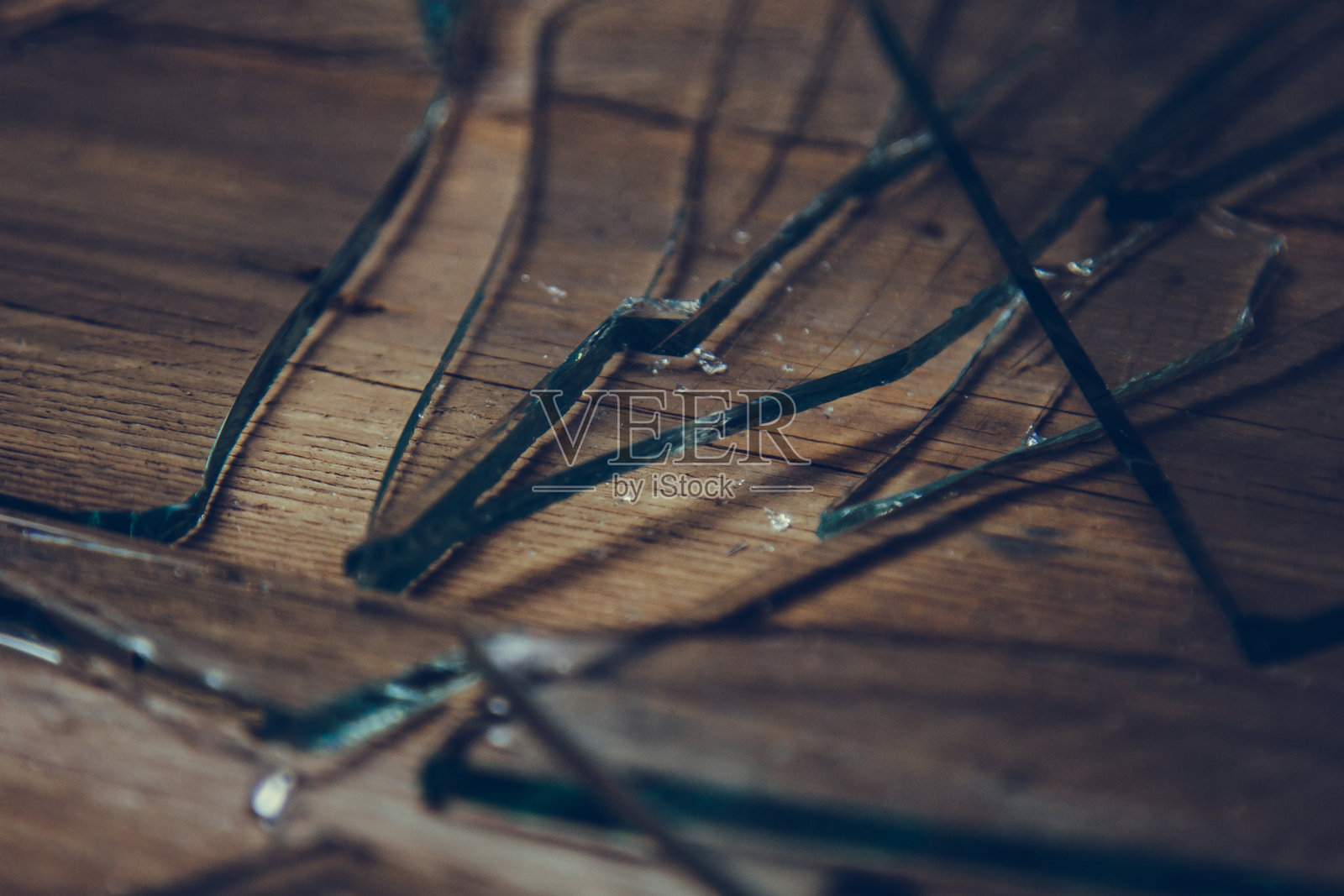 旧木地板上的碎玻璃，暴力的概念。照片摄影图片