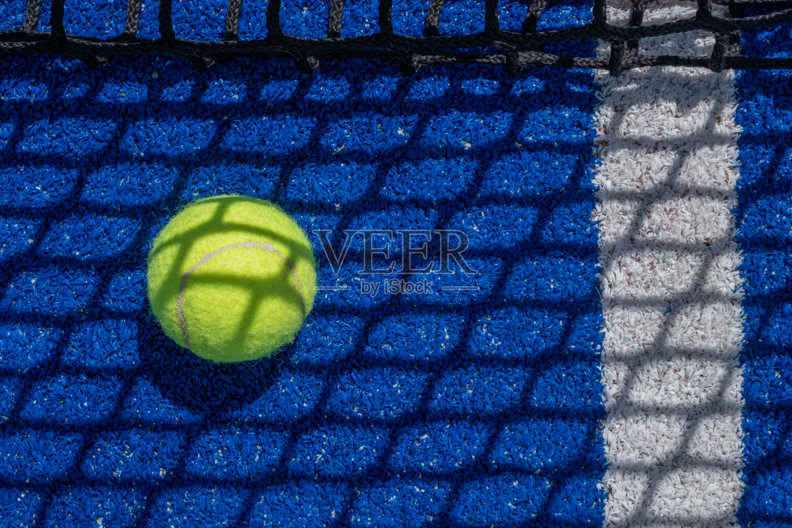 蓝色球拍网球场网投下它的影子在一个球照片摄影图片