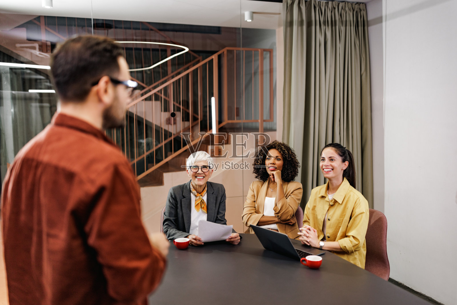雄心勃勃的女性听着男同事讲话，开着会。照片摄影图片