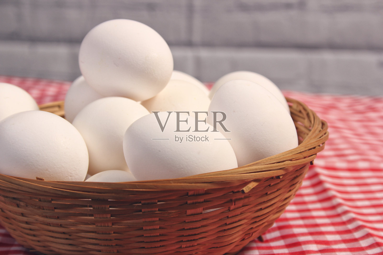 红白格子织物上的农场新鲜鸡蛋篮子照片摄影图片