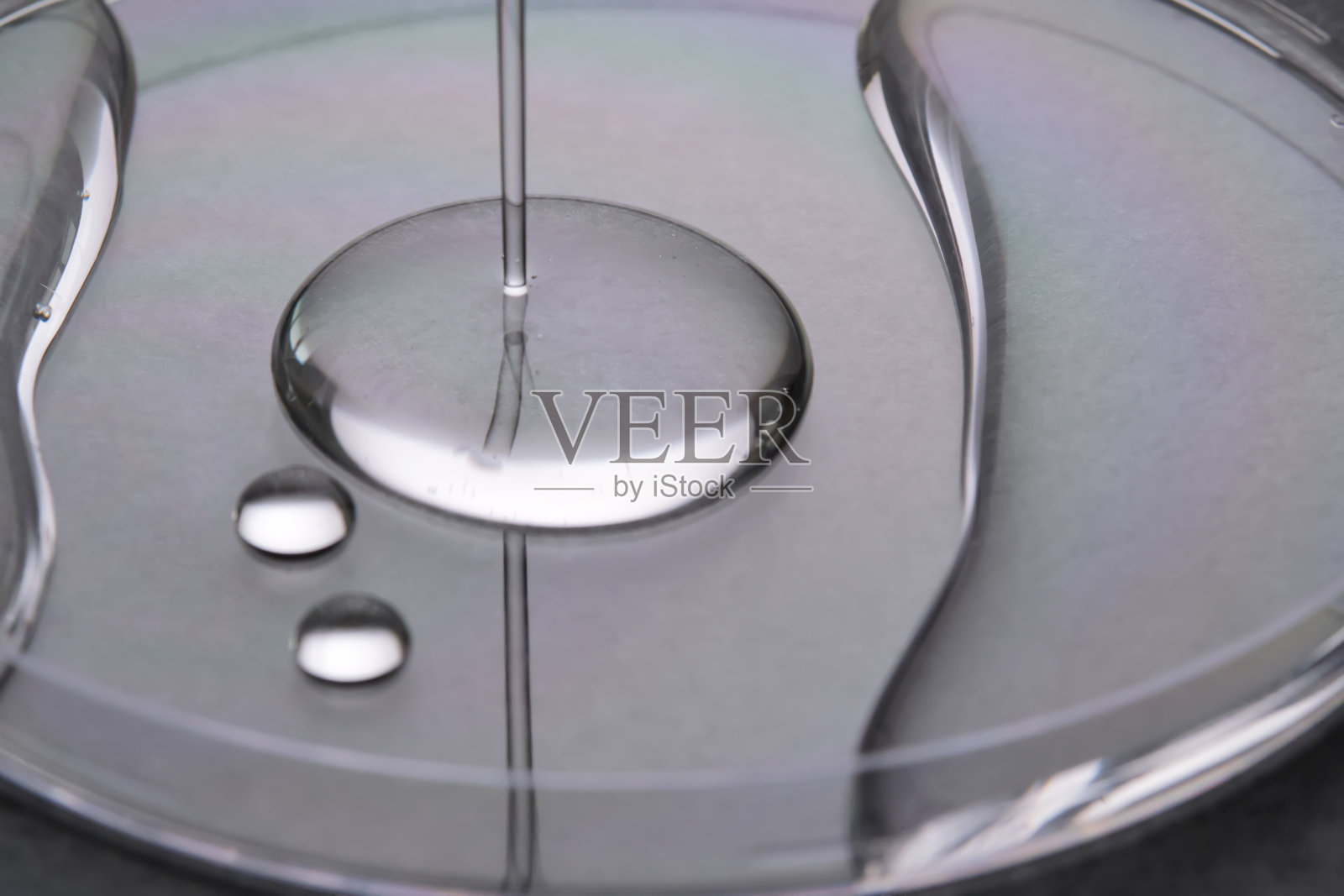 灰色背景上的一滴多汁的凝胶。照片摄影图片