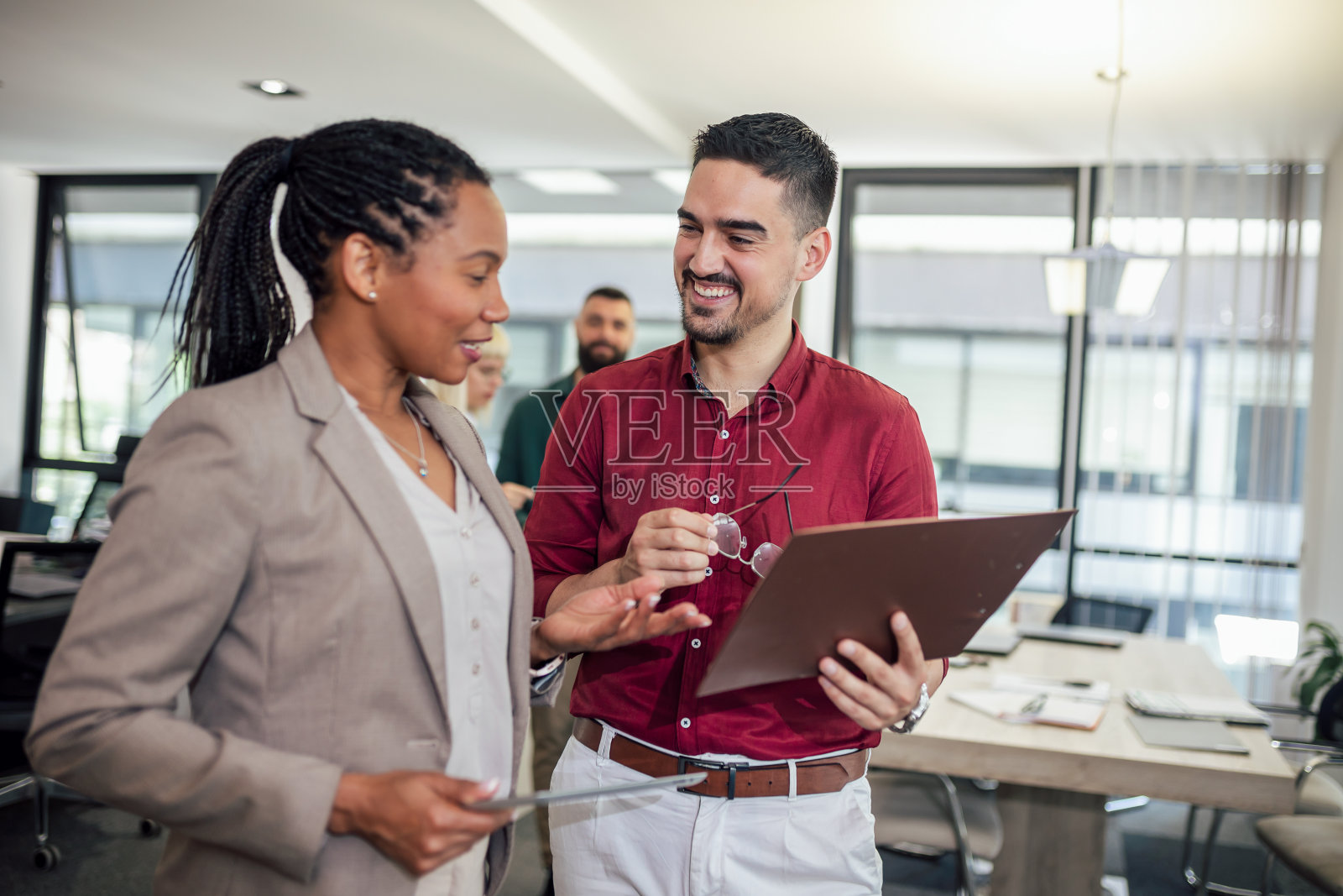 一个商业团队站在一间现代化的办公室里进行讨论照片摄影图片