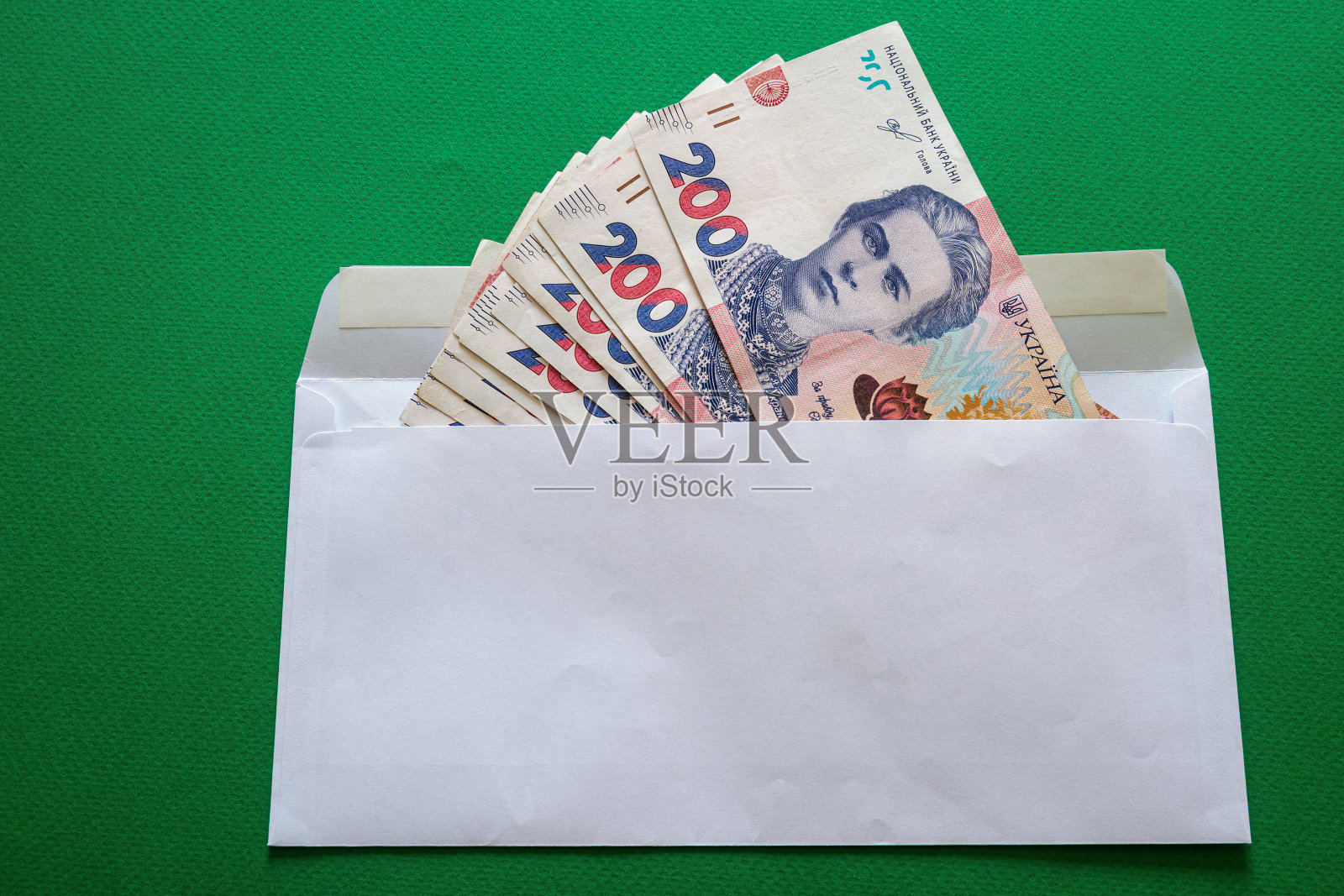 200乌克兰格里夫纳装在绿色背景的白色信封里照片摄影图片