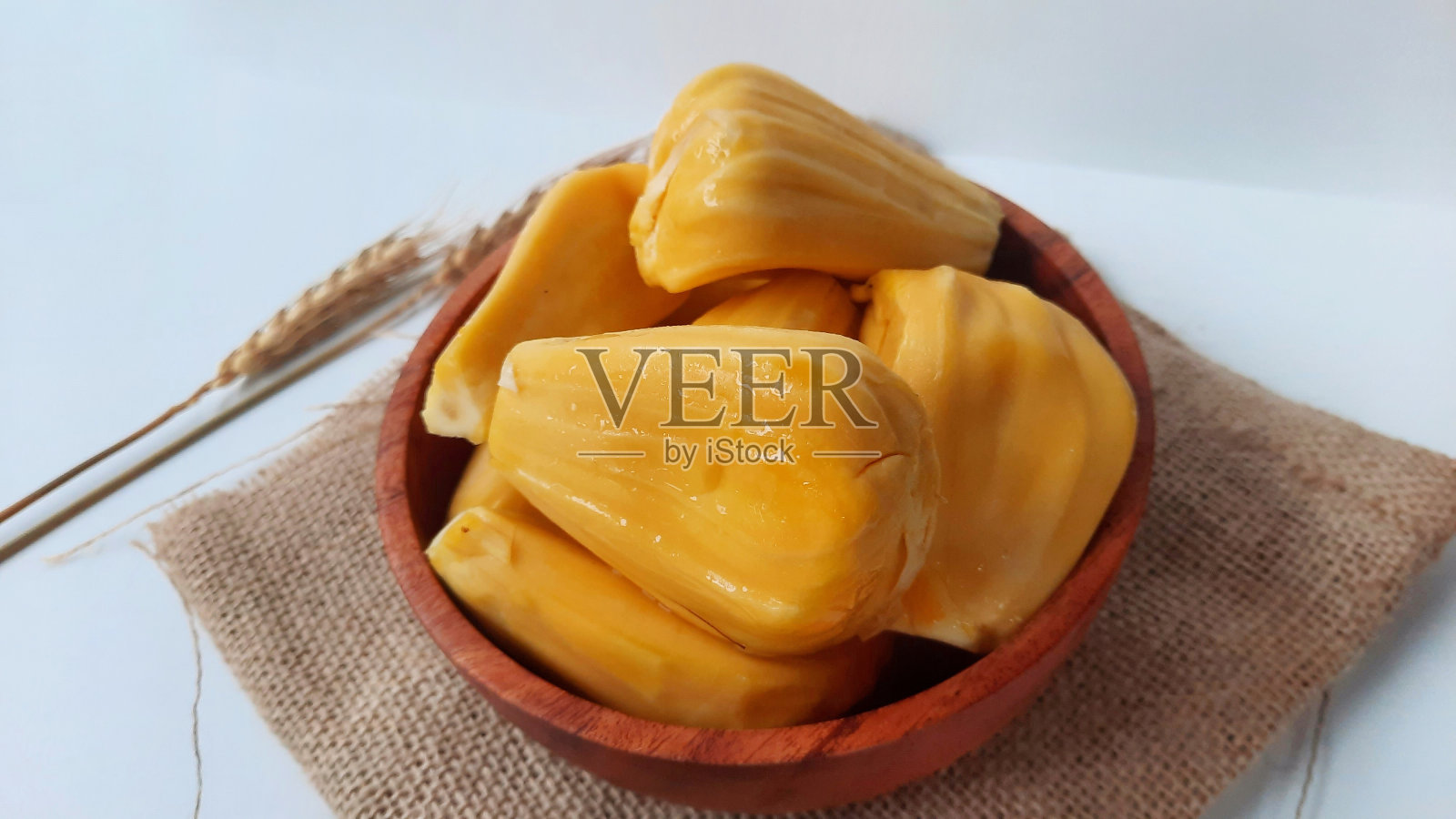 白底木碗里的剥了皮的菠萝蜜。菠萝蜜的学名是Artocarpus heterophyllus，属于桑科部落。热带水果照片摄影图片