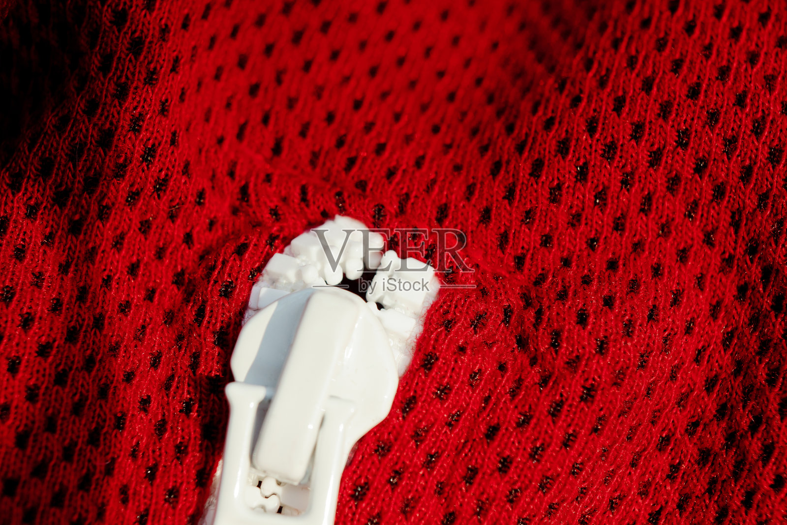 红色运动服特写俯视图。白色的滑索。透气的针织品。服装细节宏照片摄影图片