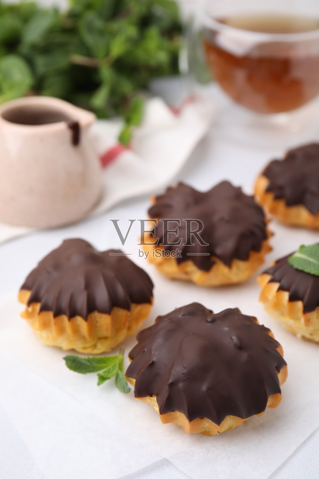 餐桌上美味的巧克力酱和薄荷泡芙，特写照片摄影图片