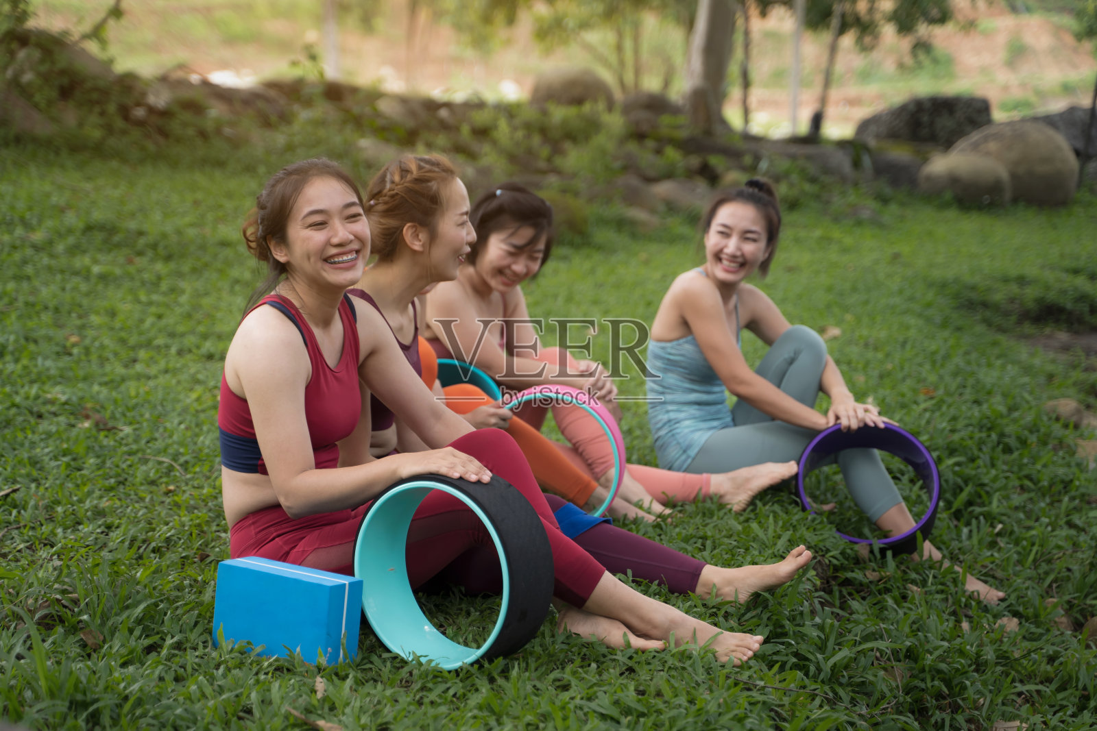 早晨，一群年轻女子在山边小溪边练习瑜伽。照片摄影图片
