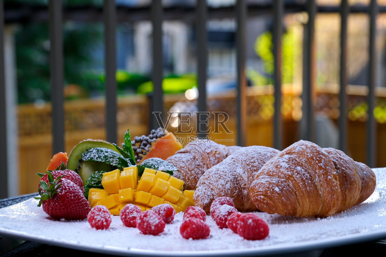 洒上糖粉的水果牛角面包美味的甜点婚礼生日派对在阳台上的私人住宅阳台上用白色大盘子庆祝浆果水果照片摄影图片