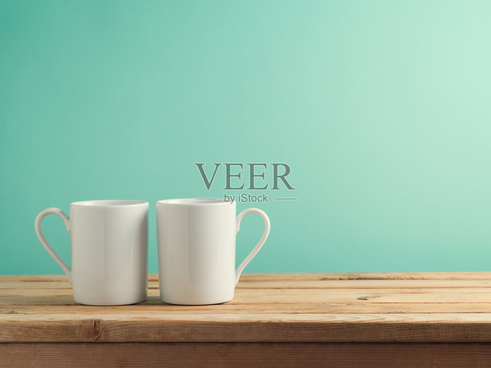 蓝色背景下木桌上的白色咖啡杯。模拟品牌和设计照片摄影图片