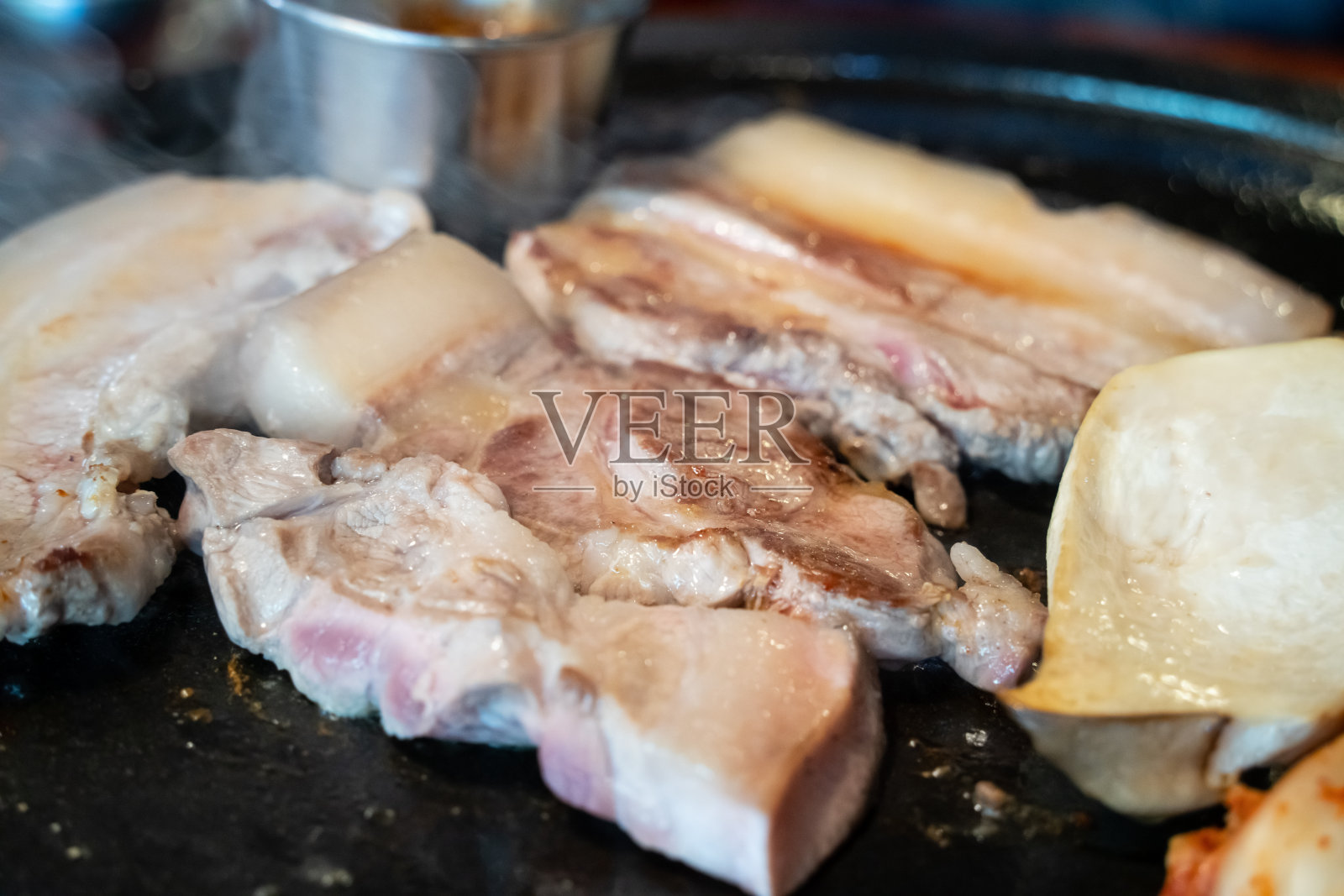 济州岛韩国餐厅新鲜美味的铁锅黑猪肉大餐。照片摄影图片