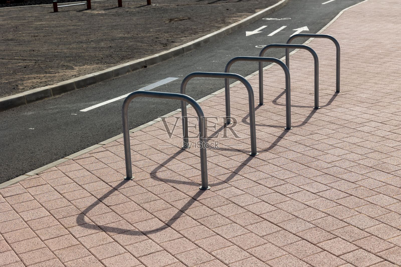 自行车停车场坐落在与道路接壤的人行道旁。照片摄影图片